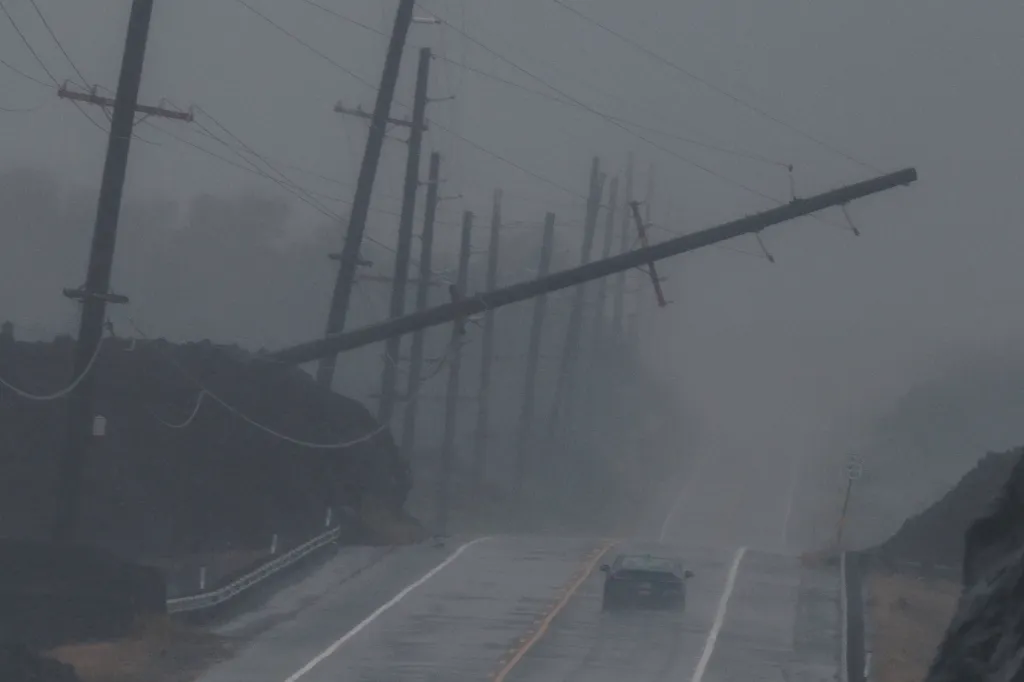 A downed utility pole hovers above a highway as Hurricane Lala strikes near Ocean View, Hawaii, on Aug. 15, 2026. 