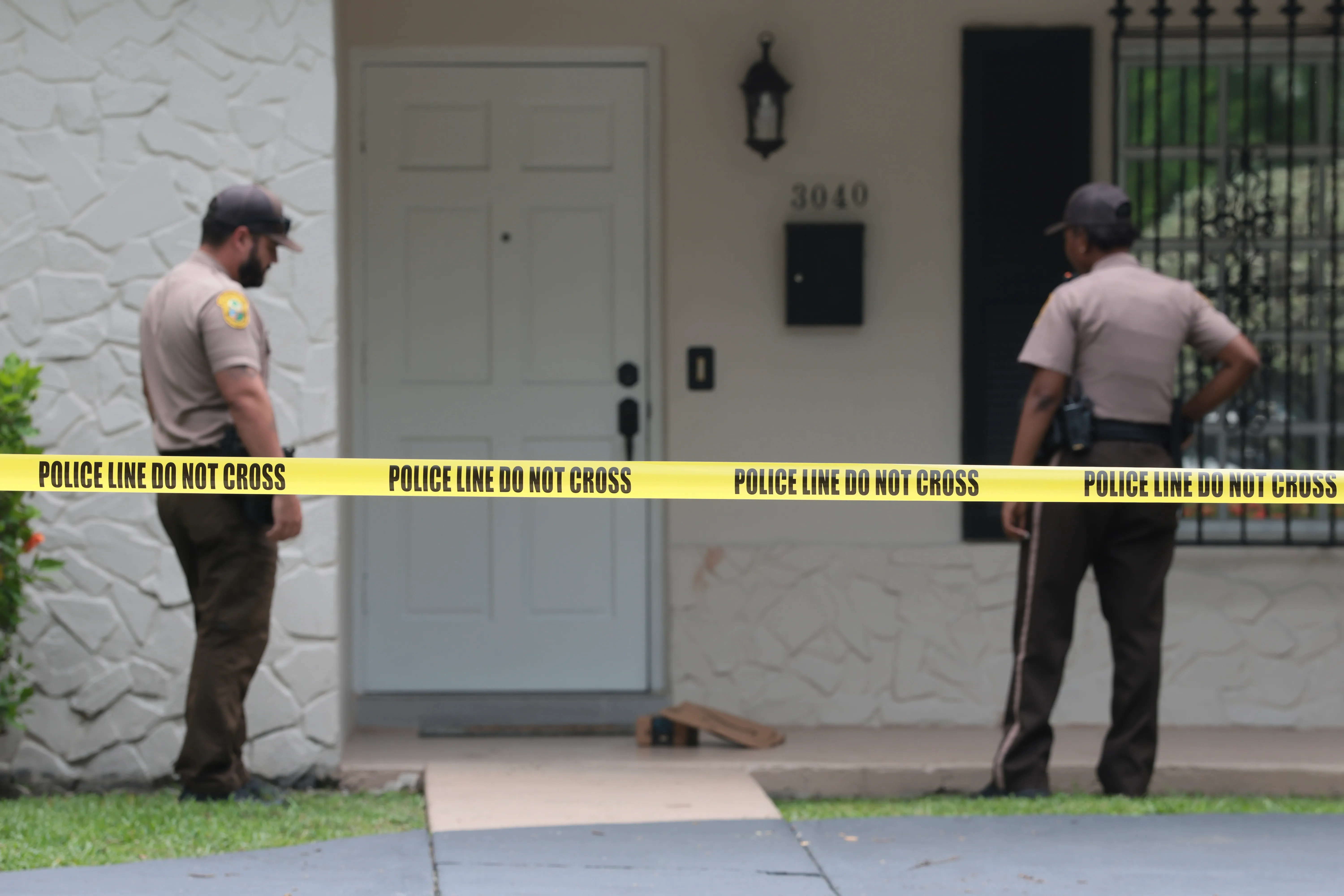 Two sheriff's deputies stand behind 