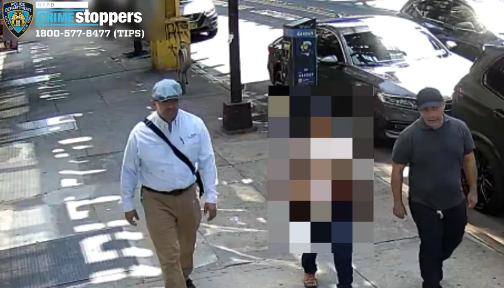 Surveillance photo of two men identified as con artists on a city street.