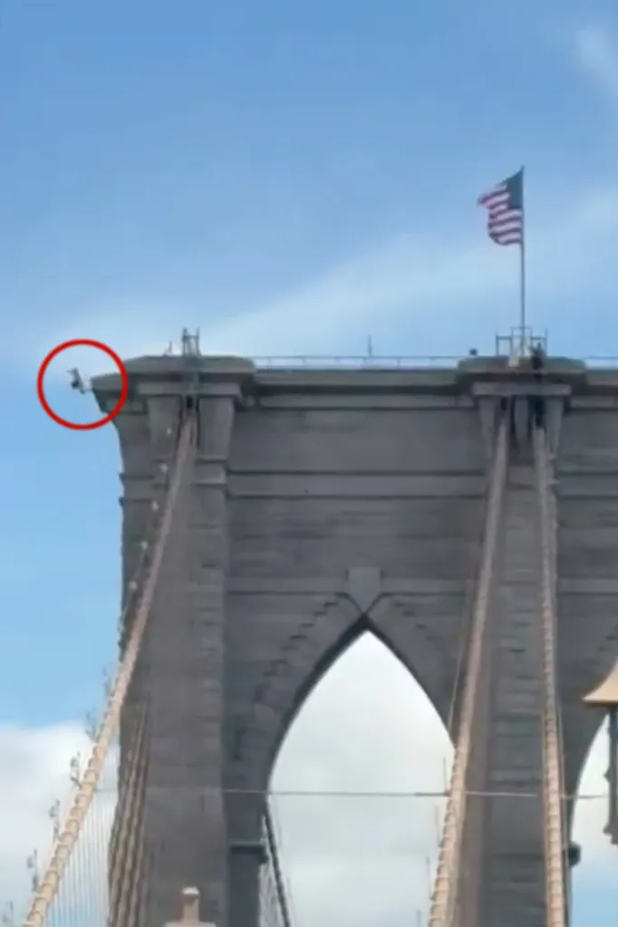 Galymzhan Abaildayev climbing the Brooklyn Bridge, with an American flag flying above.
