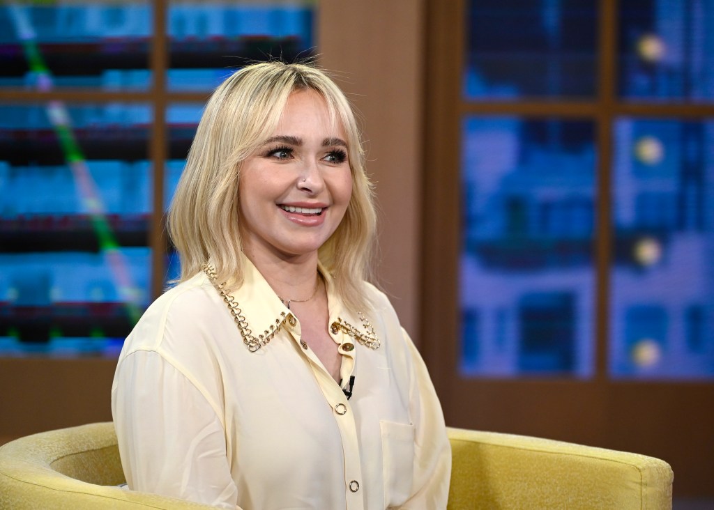Hayden Panettiere wearing a cream-colored collared shirt with golden chain detailing.