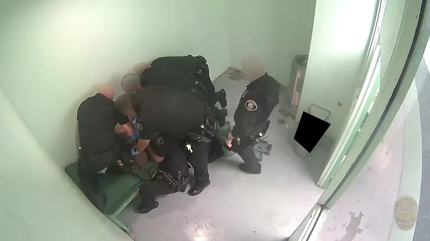 Police officers arresting Jose Carlos Hoyos-Munoz in a jail cell.