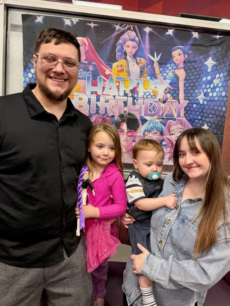 Hope Hobbs, a 30-year-old stay-at-home mom, with her husband and two young children in front of a colorful