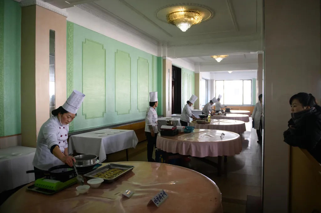 Chefs cooking at individual stations during North Korea's national cooking competition.