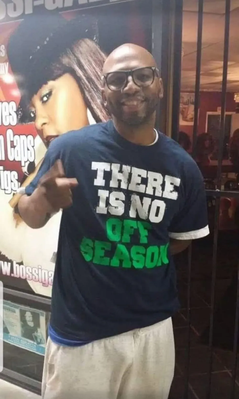 A bald man wearing glasses and a t-shirt that says