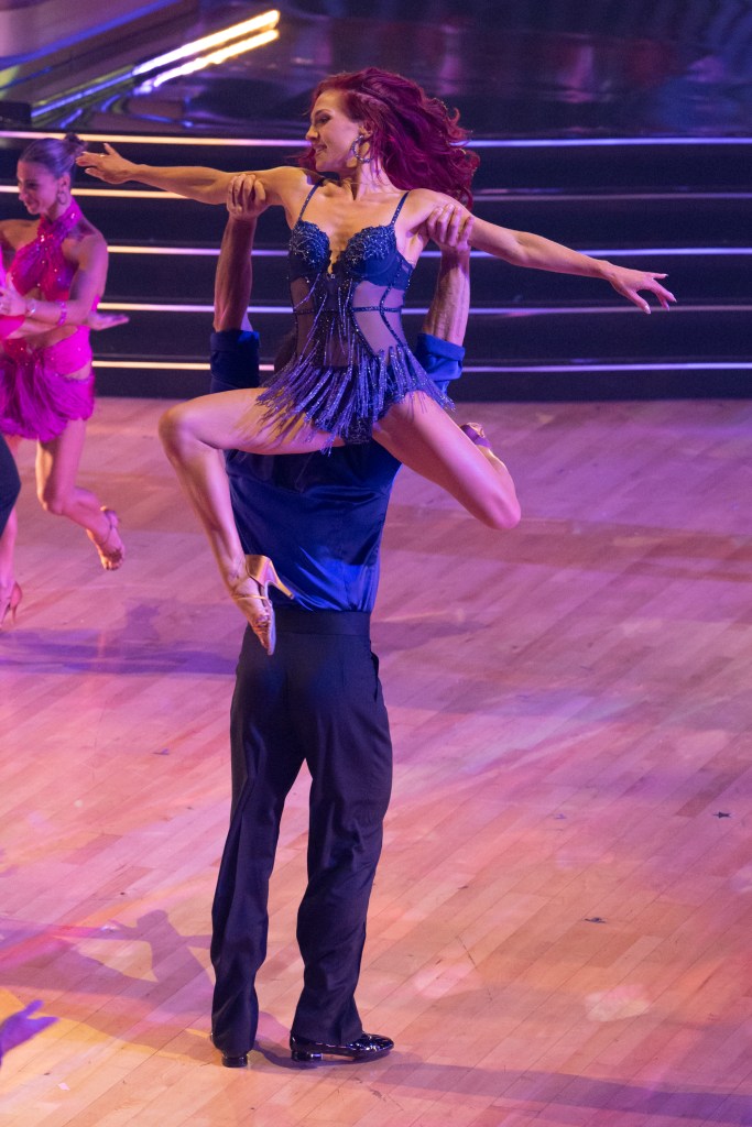 Sharna Burgess being lifted by her dance partner during a dance performance.