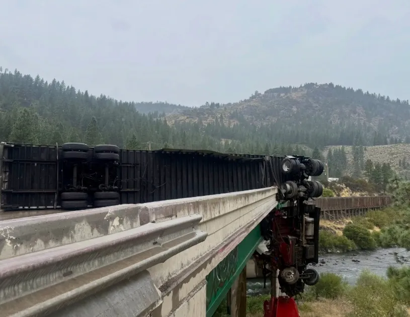Semi-truck dangling over the side of a bridge after a single-vehicle crash.