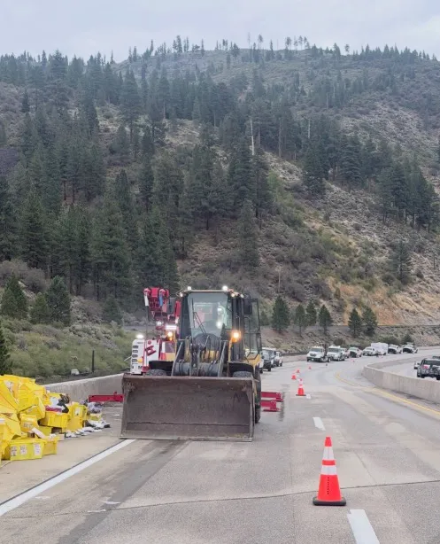 Front-end loader and tow truck cleaning up a crash site on Interstate 80.