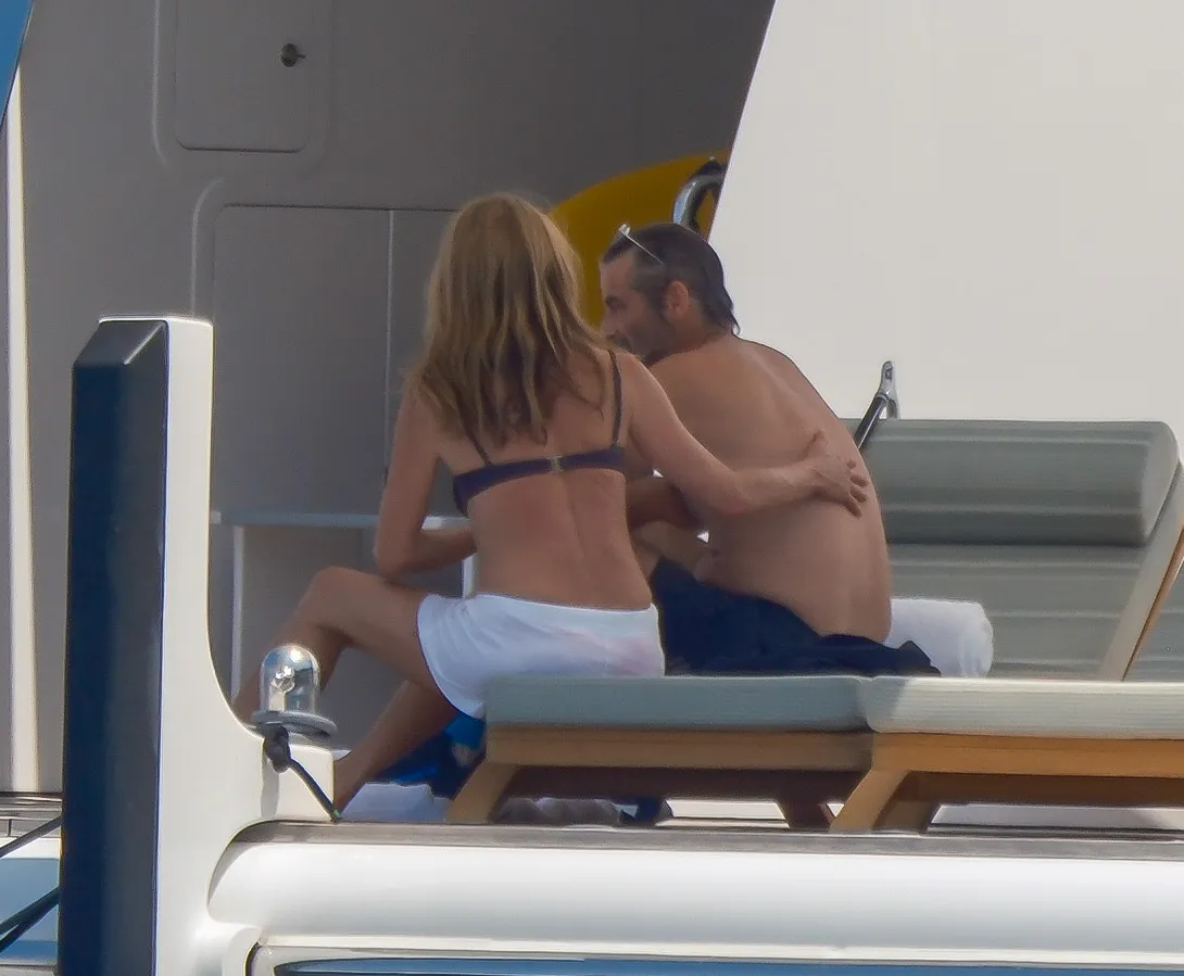 Jennifer Aniston and Jim Curtis embracing on a yacht.