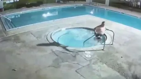 CCTV footage of Greg Medina sitting in a hot tub next to a swimming pool.
