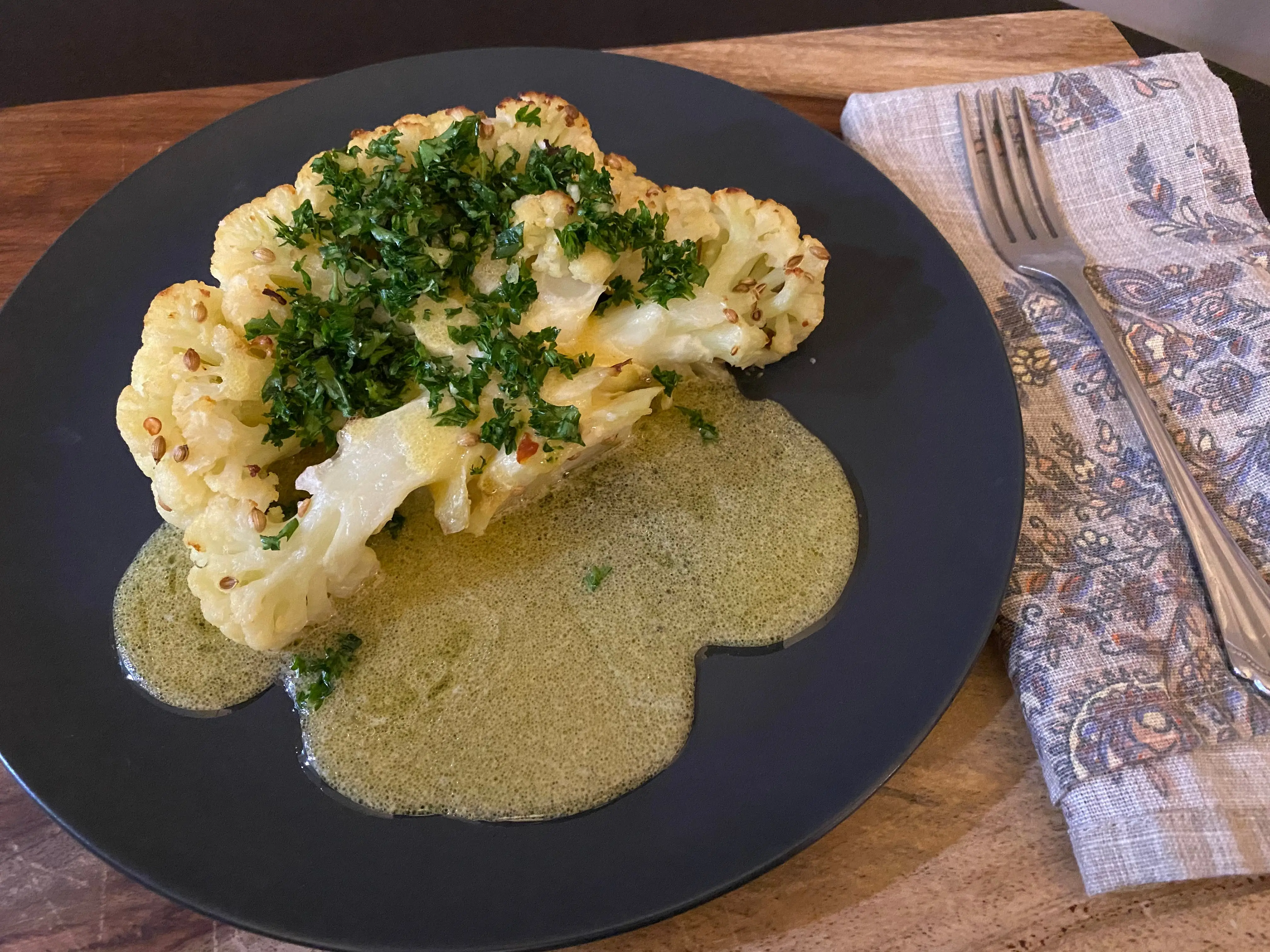 cauiflower on plate with sauce, herbs on top
