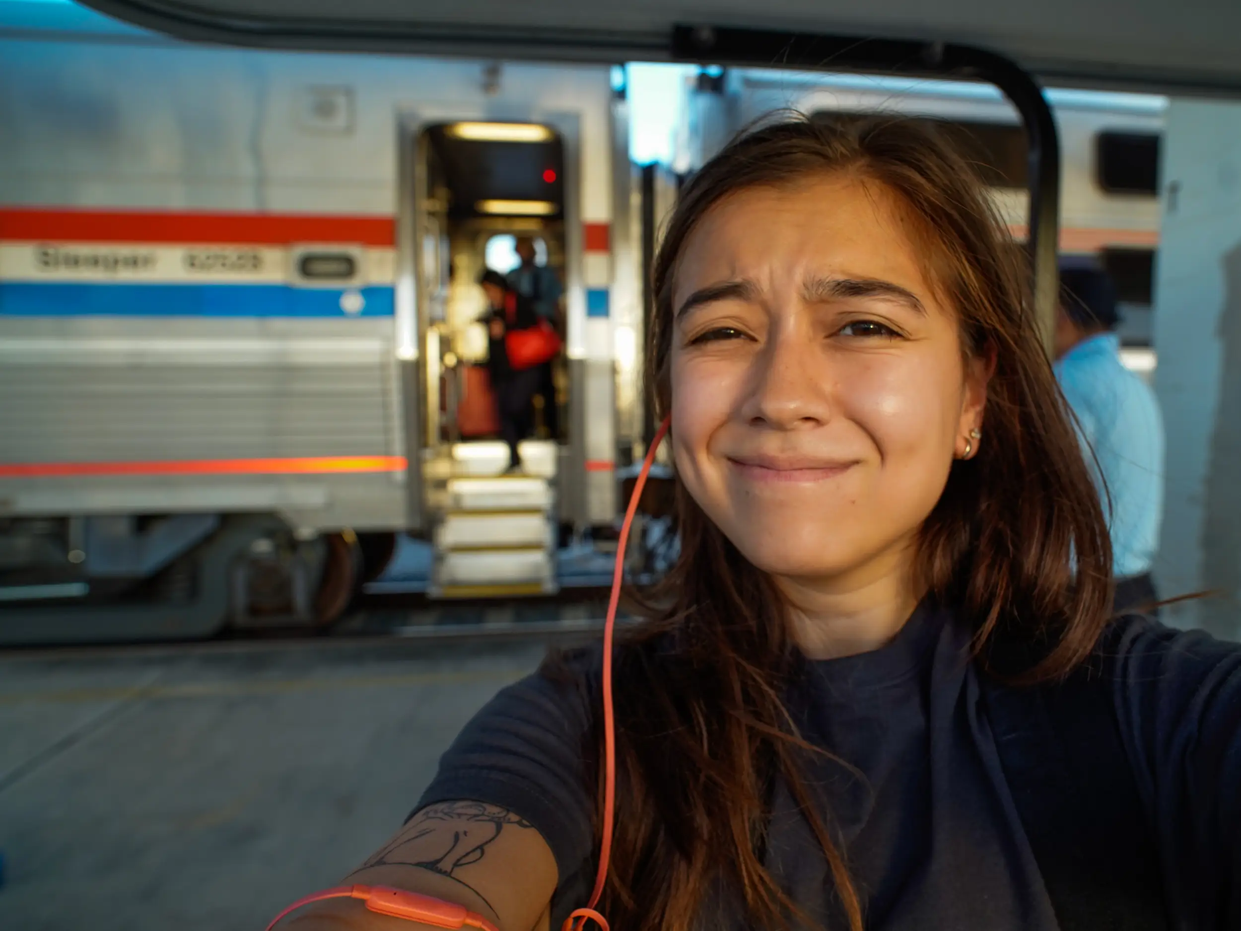 A woman taking a selfie in front of a train.