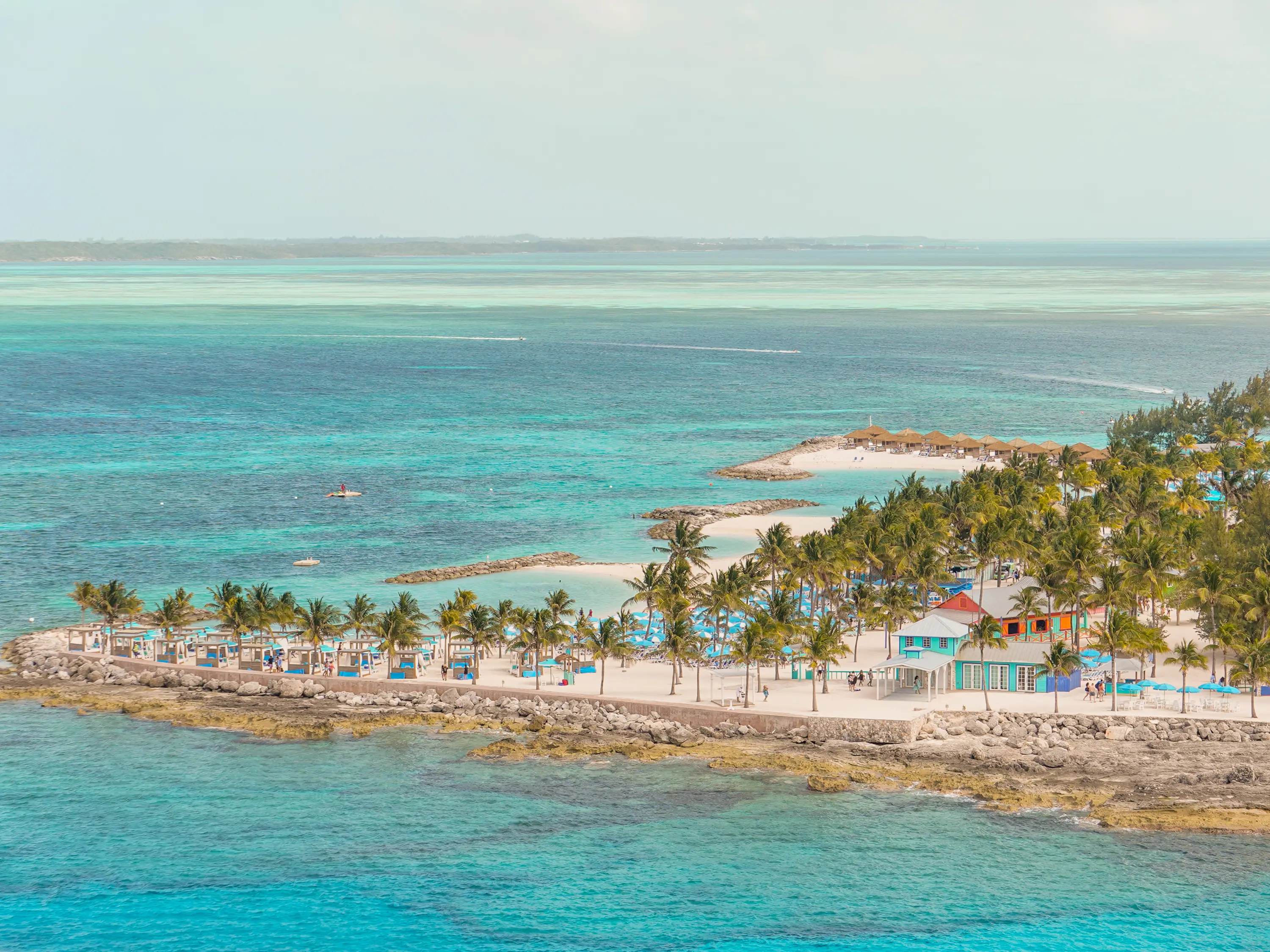 The edge of CocoCay seen from above with clear ocean waters in the foreground and background