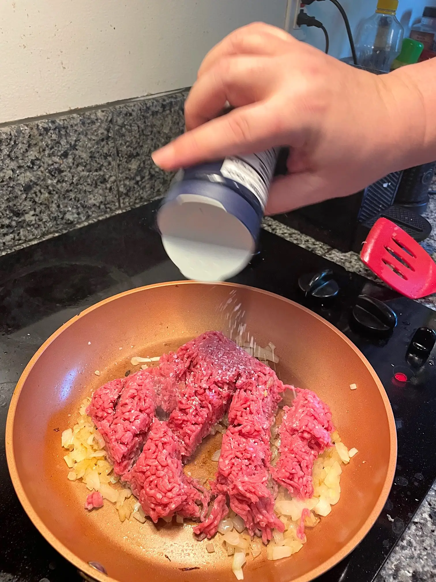 Salting ground beef in pan for yemista