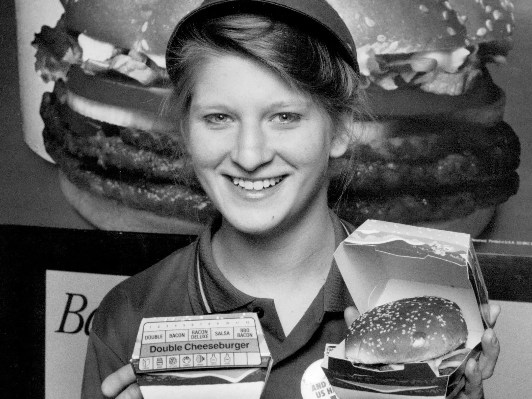 A crew member at Burger King holds up a double cheeseburger in 1989