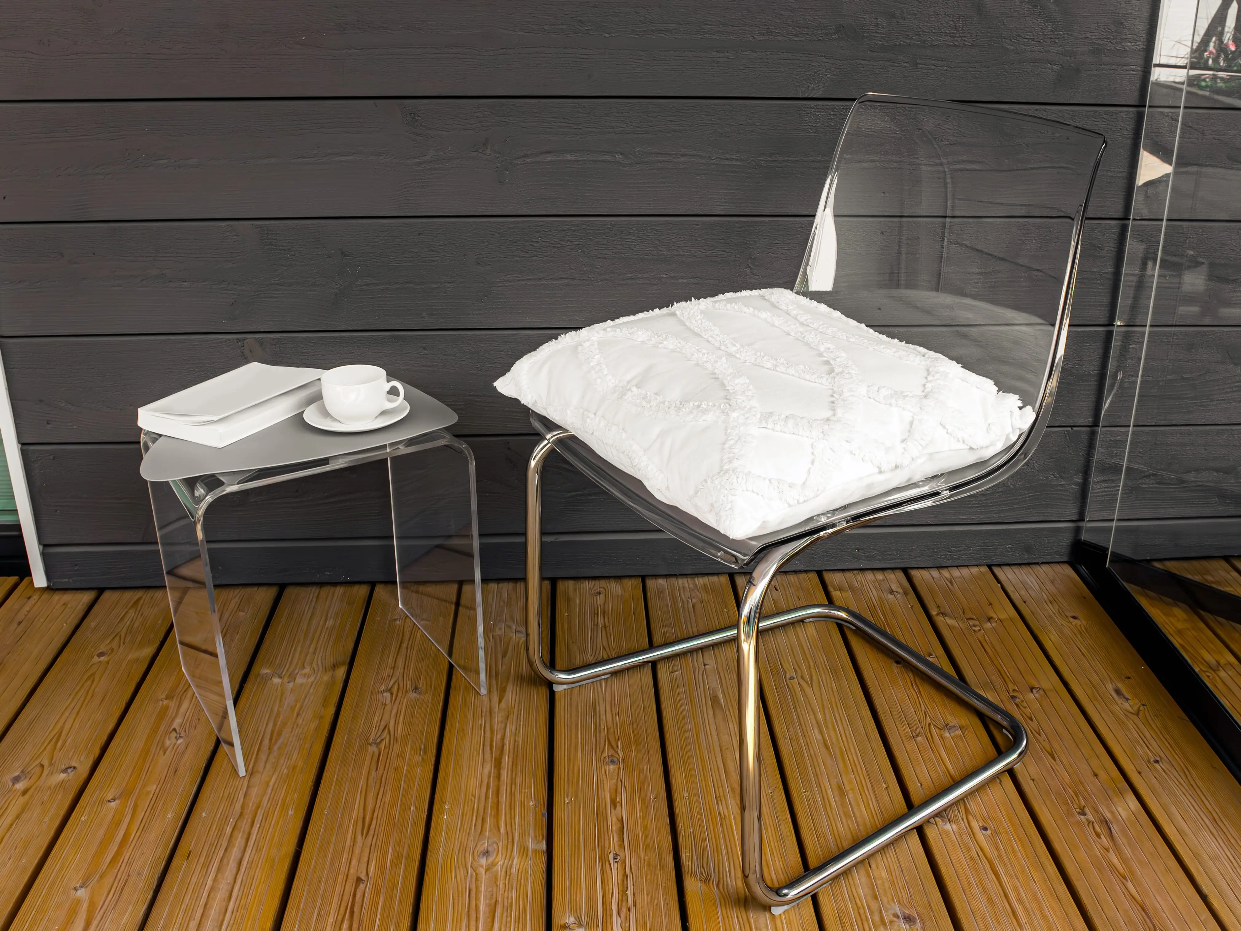 acrylic side table and chair on a wooden deck
