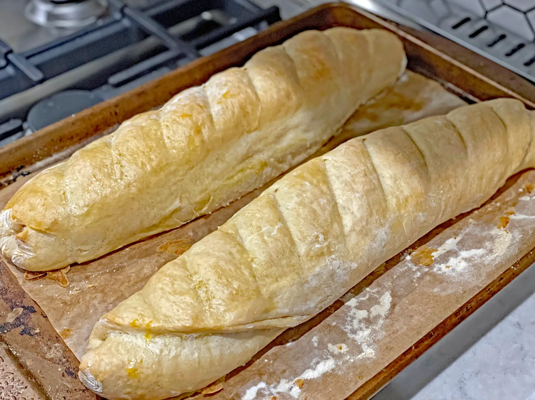 two freshly baked baguettes on a cookie sheet
