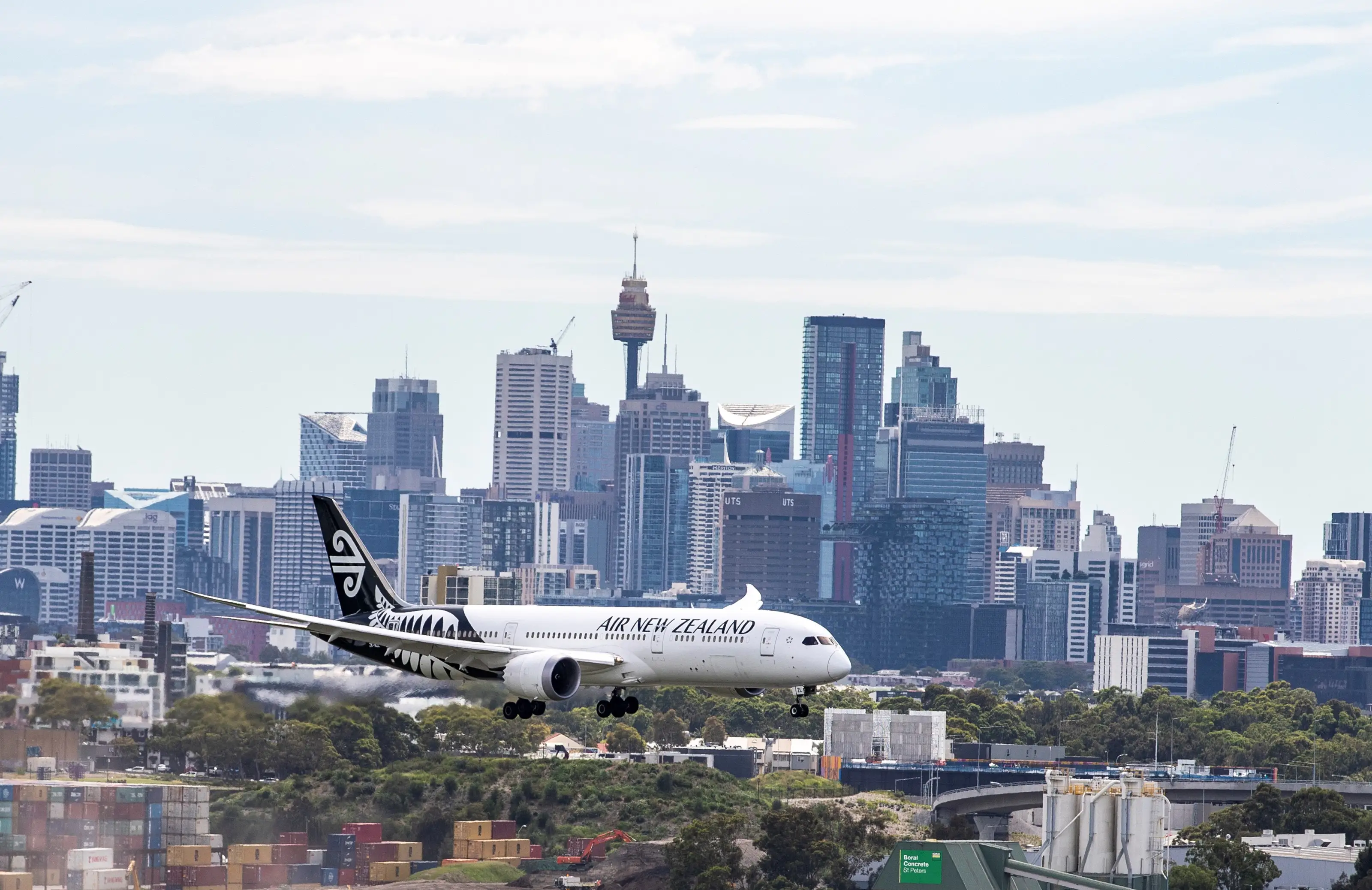 An Air New Zealand plane flies in front of the Sydney skyline