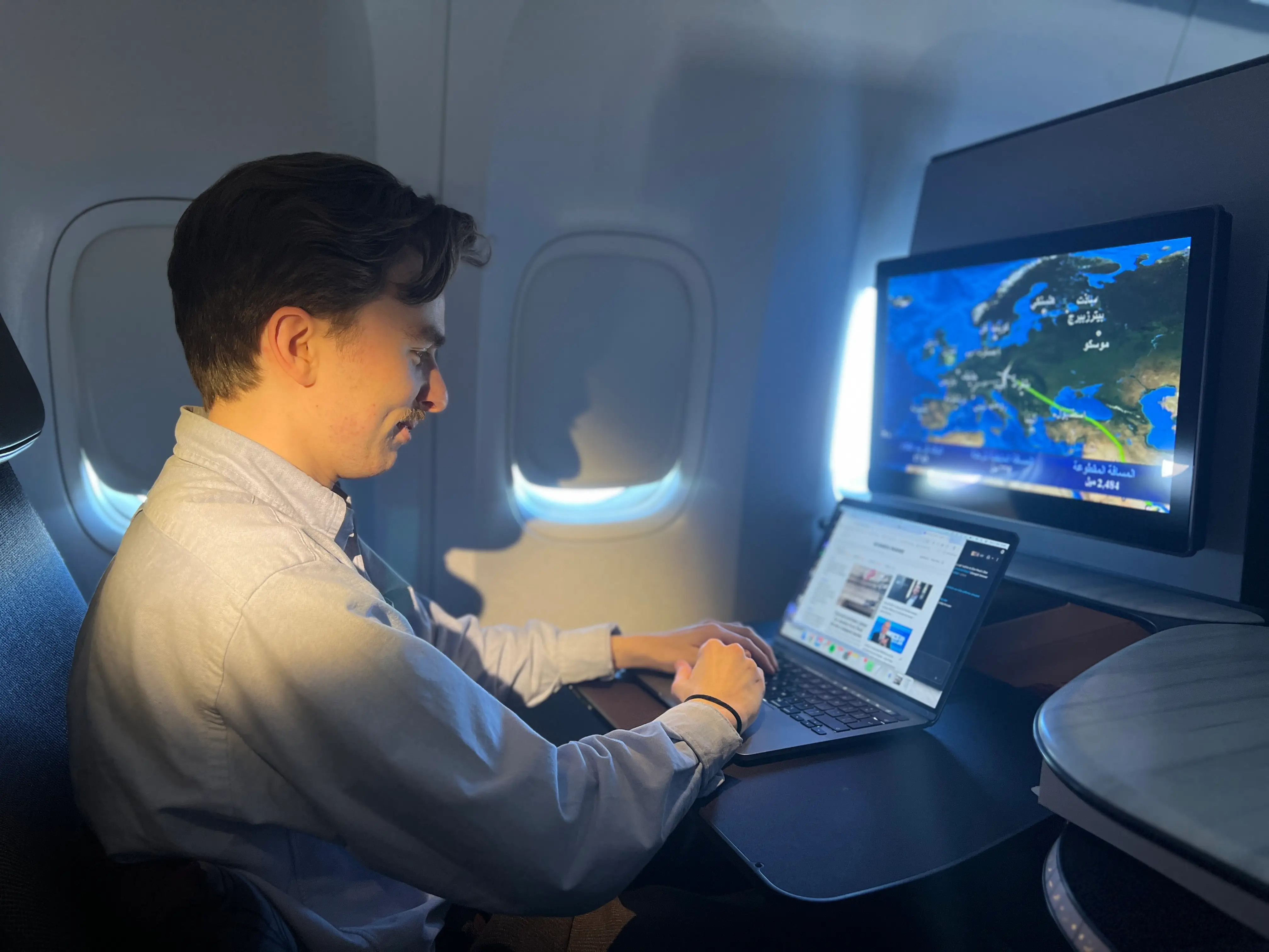 Business Insider's author works on his laptop in a Qatar Airways QSuite during its first Starlink flight