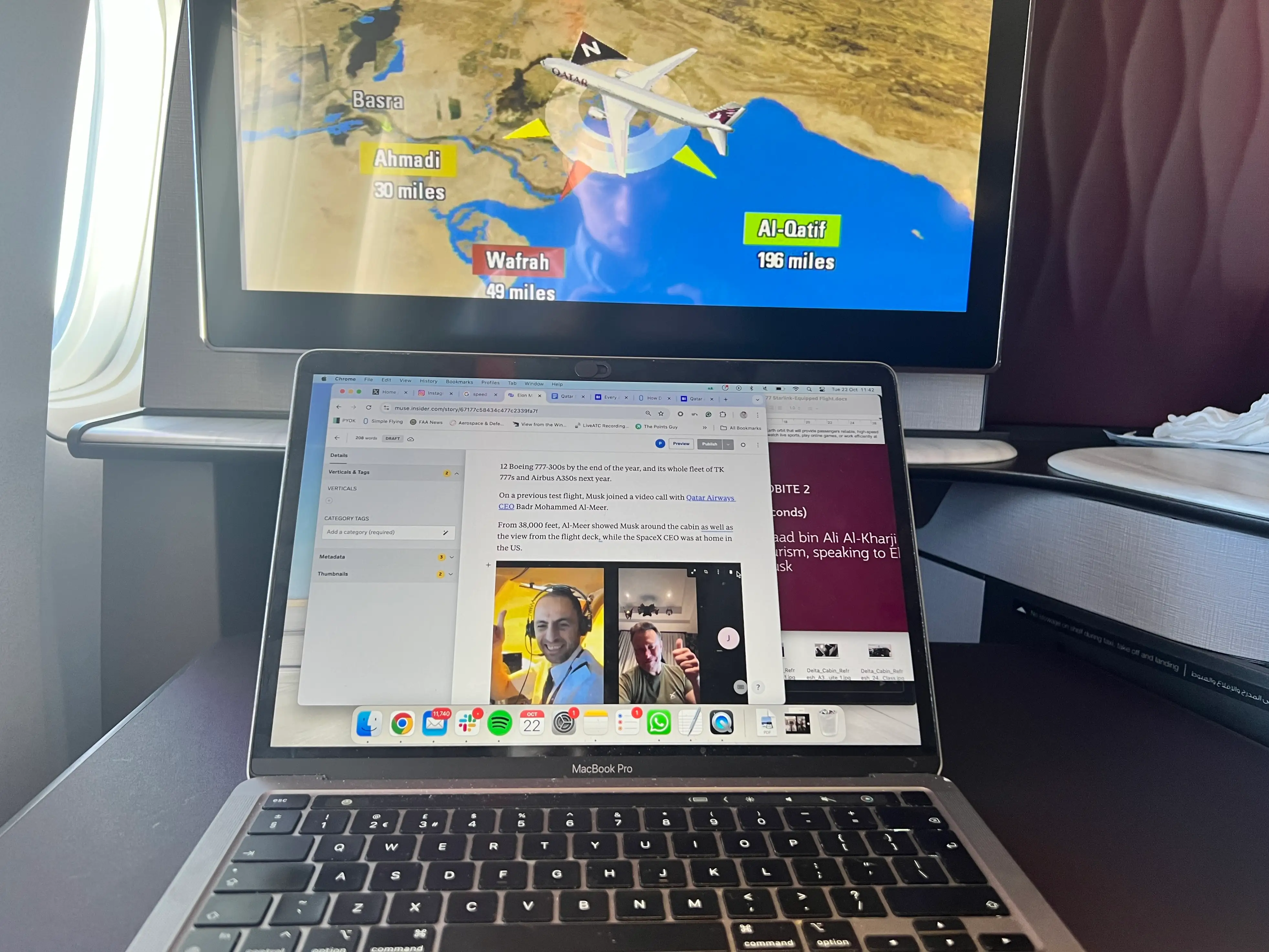 A first-person perspective from Qatar Airways' QSuite writing a Business Insider article with the flight map on screen.