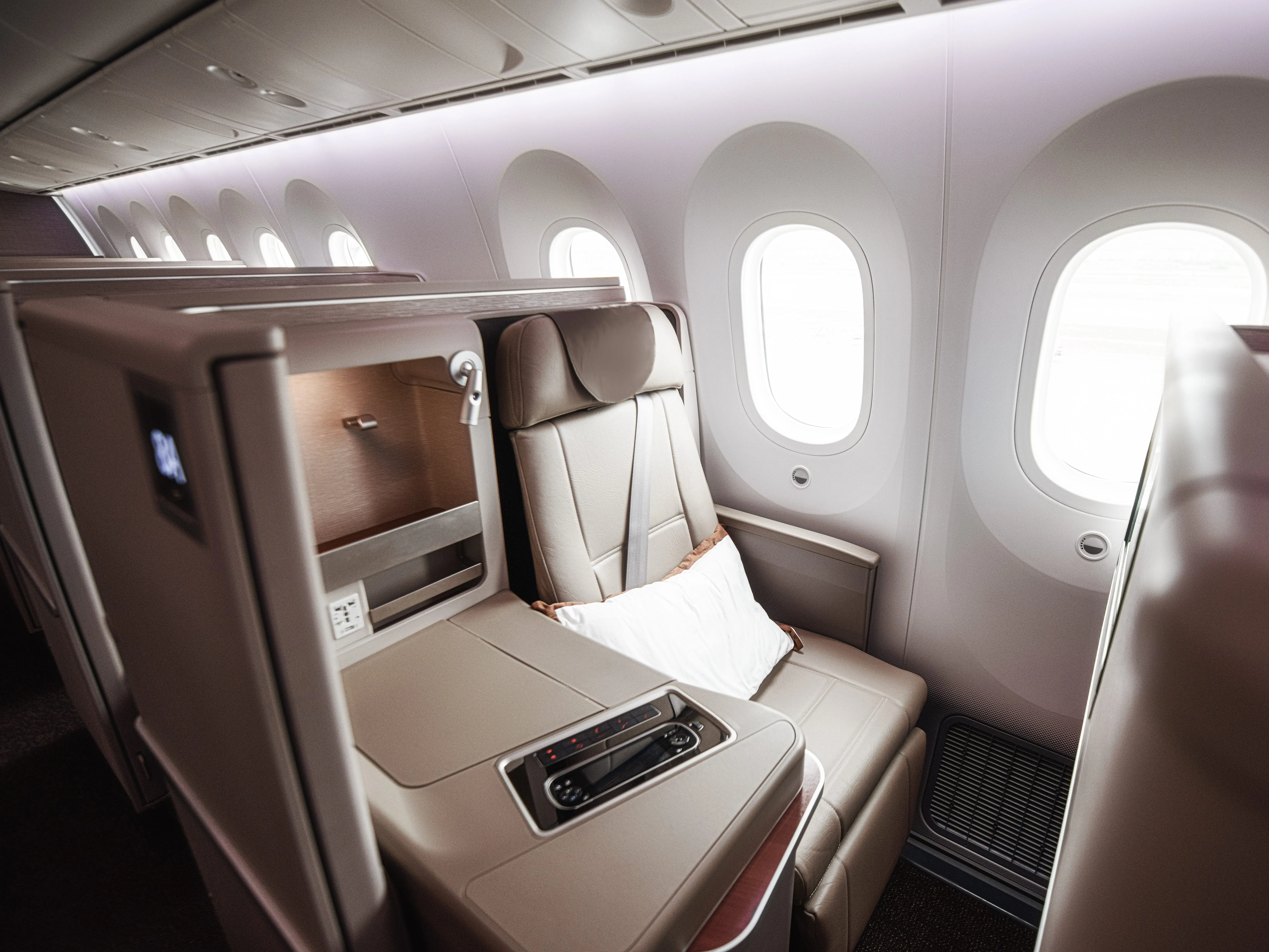 Luxurious seats with doors inside a first-class cabin on a plane