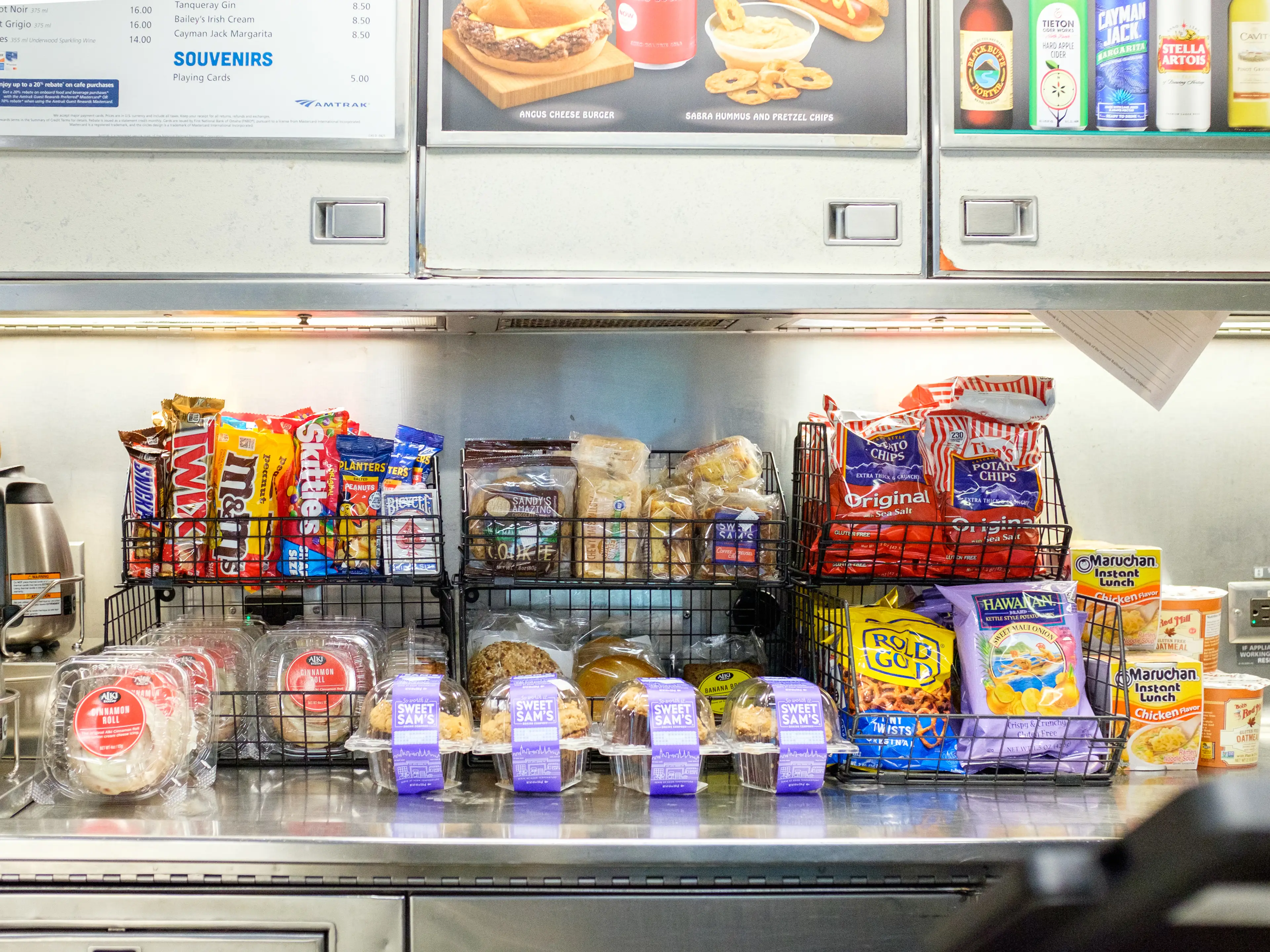 Trays of snacks behind a counter in an Amtrak cafe car