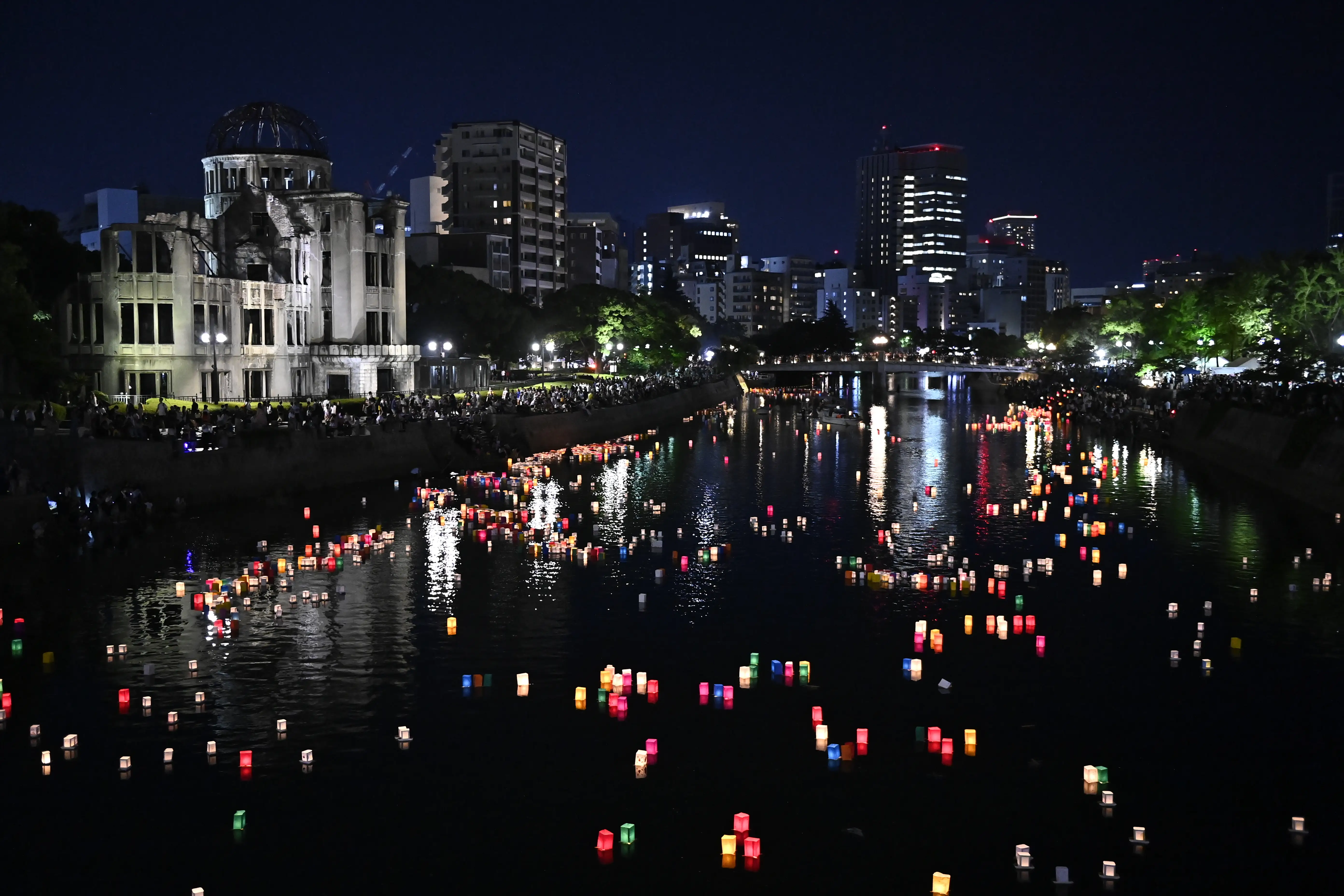 Candles and paper lanterns float on the Motoyasu River in front of the Atomic Bomb Dome.