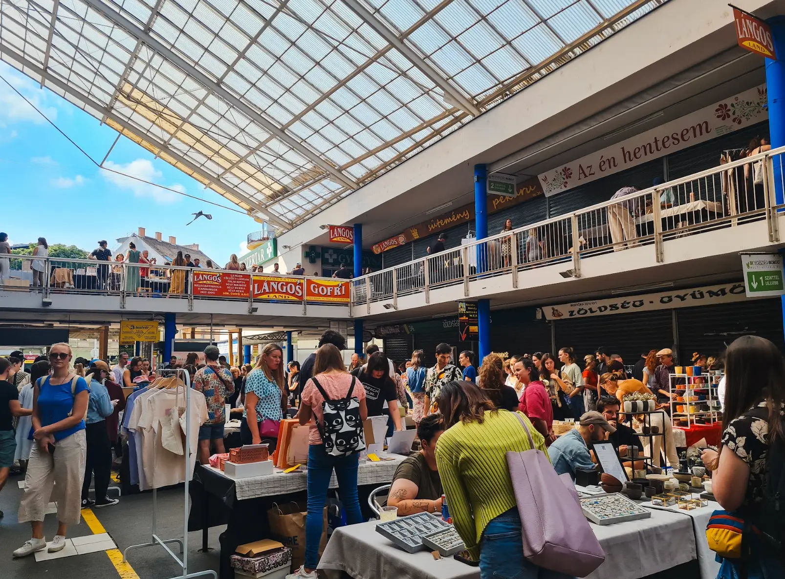 Crowds of people at a covered market with two levels.