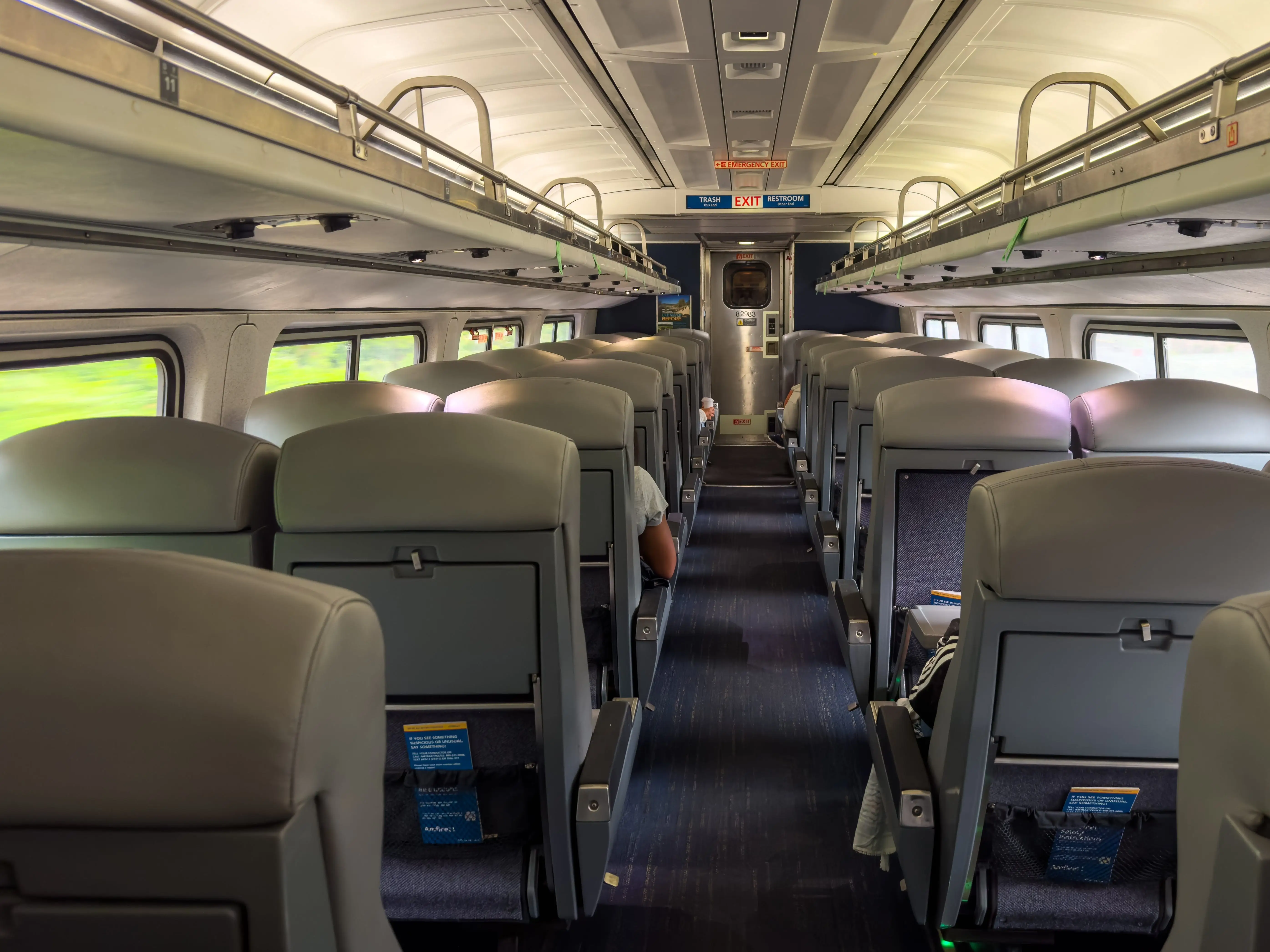 The interior of an Amtrak train with two seats in each row.