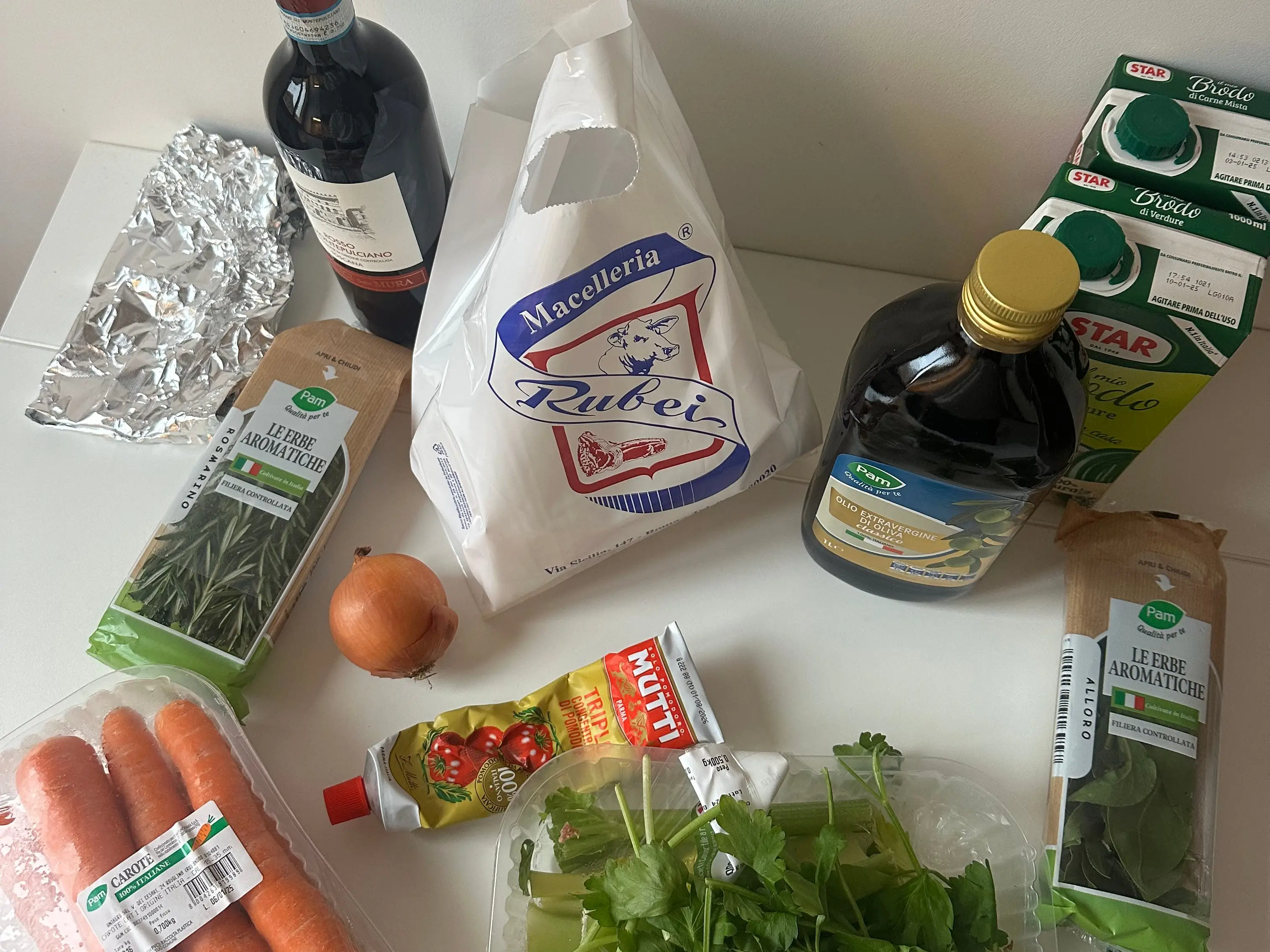The author's groceries laid on a counter, including wine, carrots, herbs, and more.