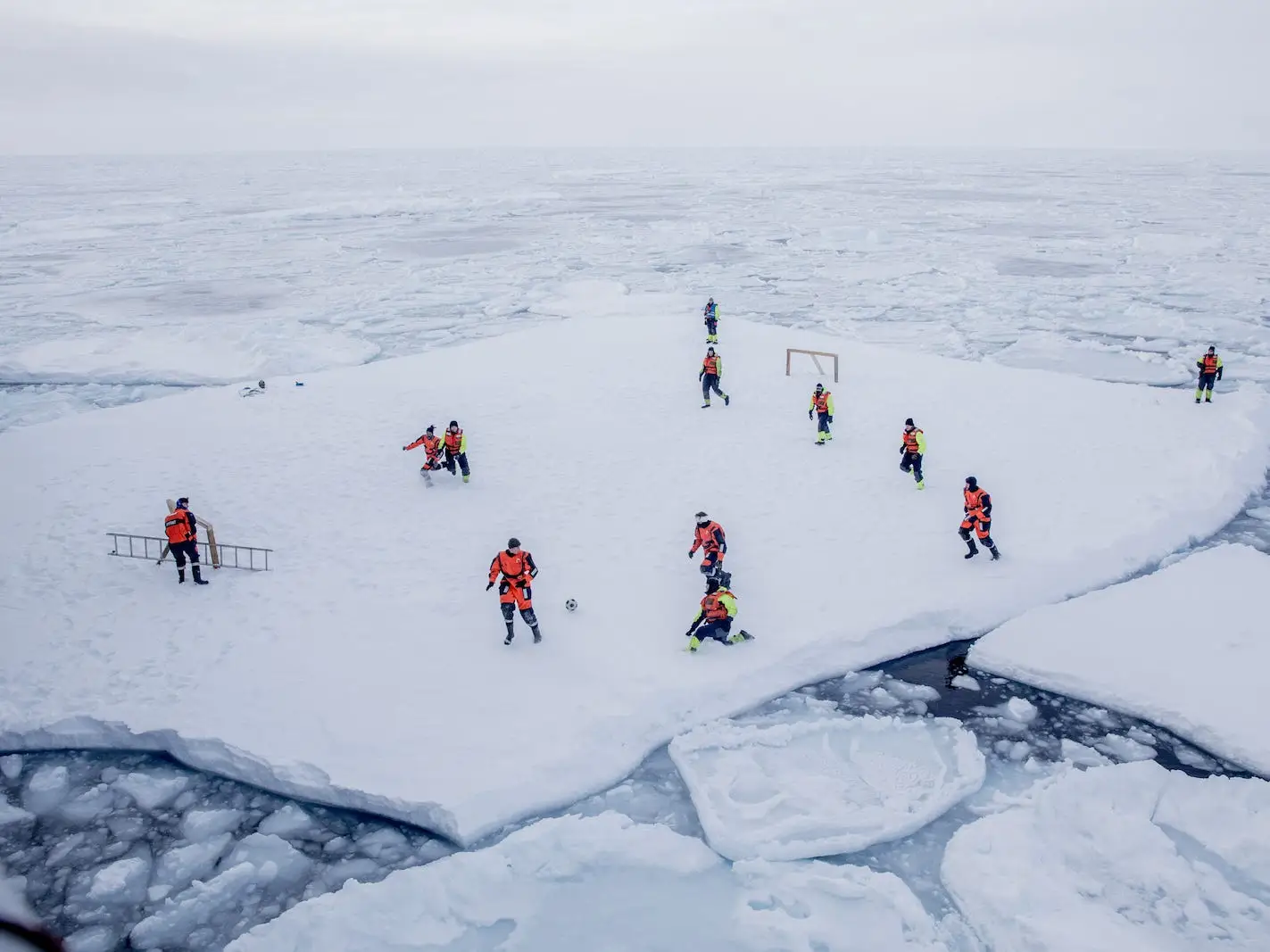KV Svalbard's crew, formed by Norwegian Navy privates and scientists from Norwegian Institute of Marine Research, play soccer as they are protected from polar bears by armed guards in the arctic environment in the sea around Greenland, March 22, 2018. Picture taken March 22, 2018.