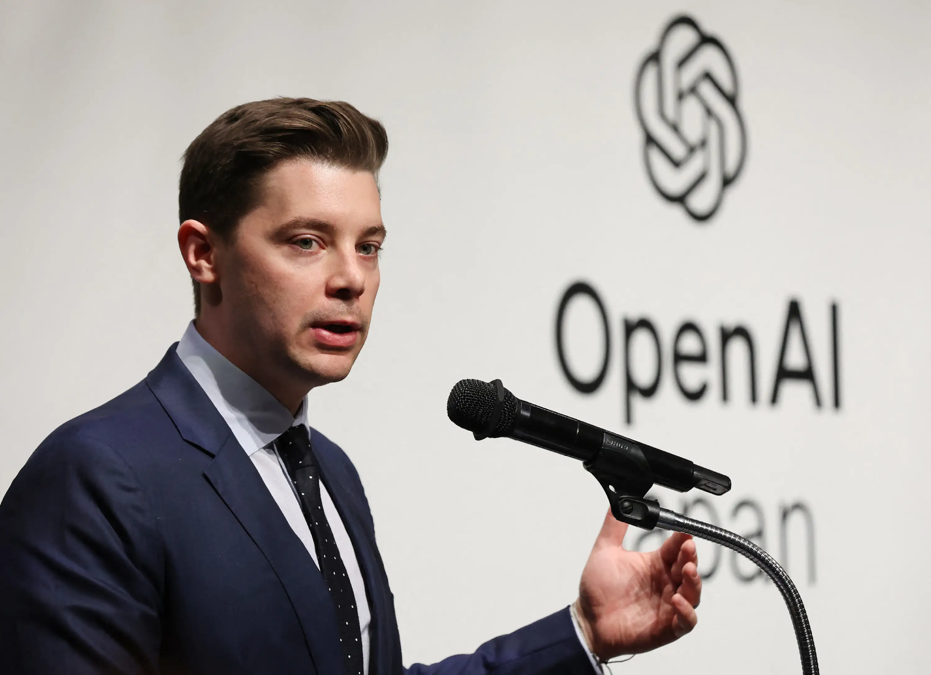 Brad Lightcap is pictured speaking at an OpenAI event.