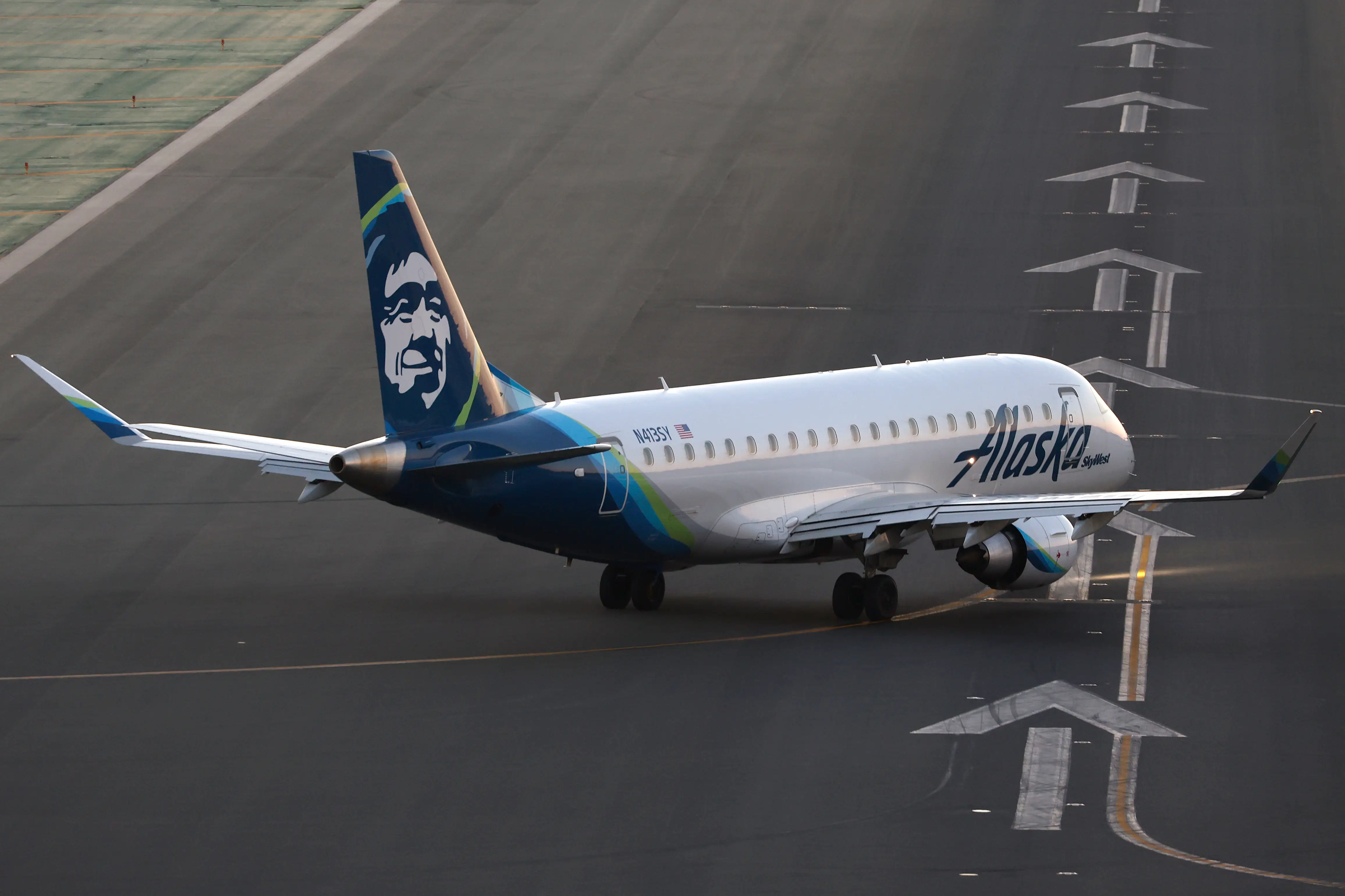 A Alaska Airlines SkyWest Embraer E175LR airplane taxis to depart from San Diego International Airport to Sacramento at sunset on November 22, 2024 in San Diego, California.