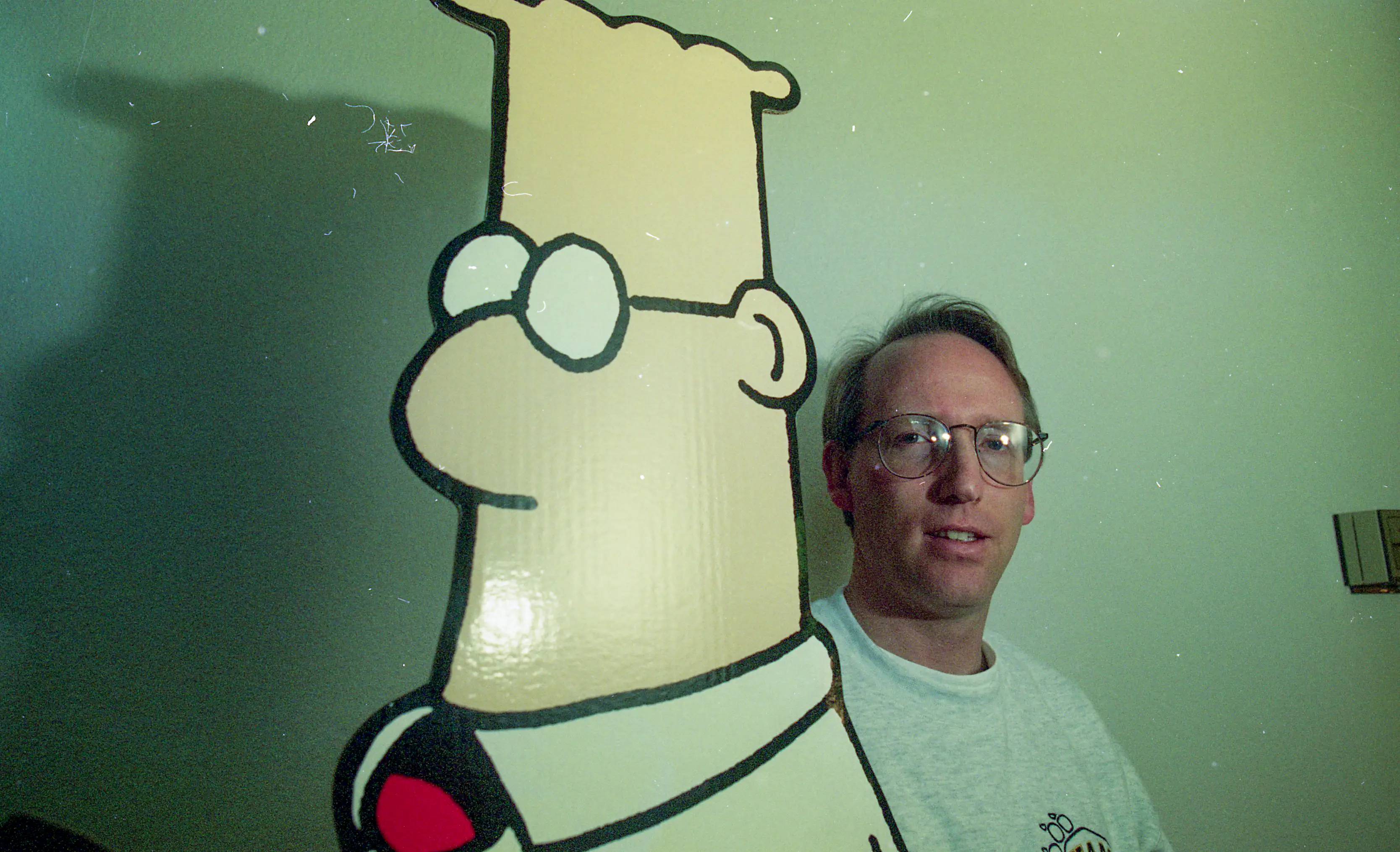 Scott Adams next to a cut out of his creation comic book character Dilbert