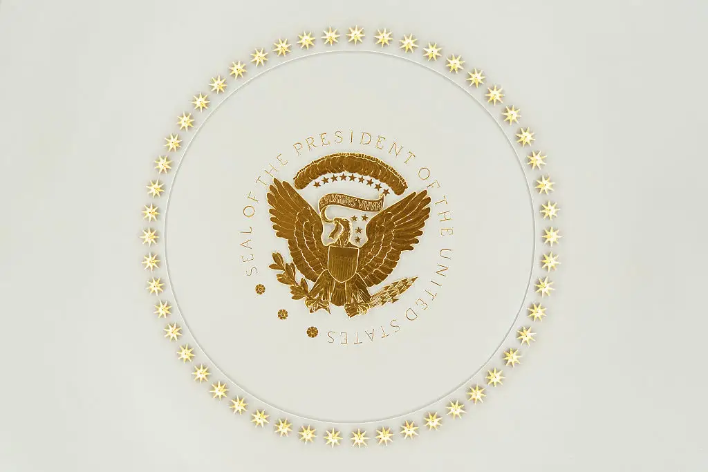 The seal of the president covered in gold in the Oval Office.
