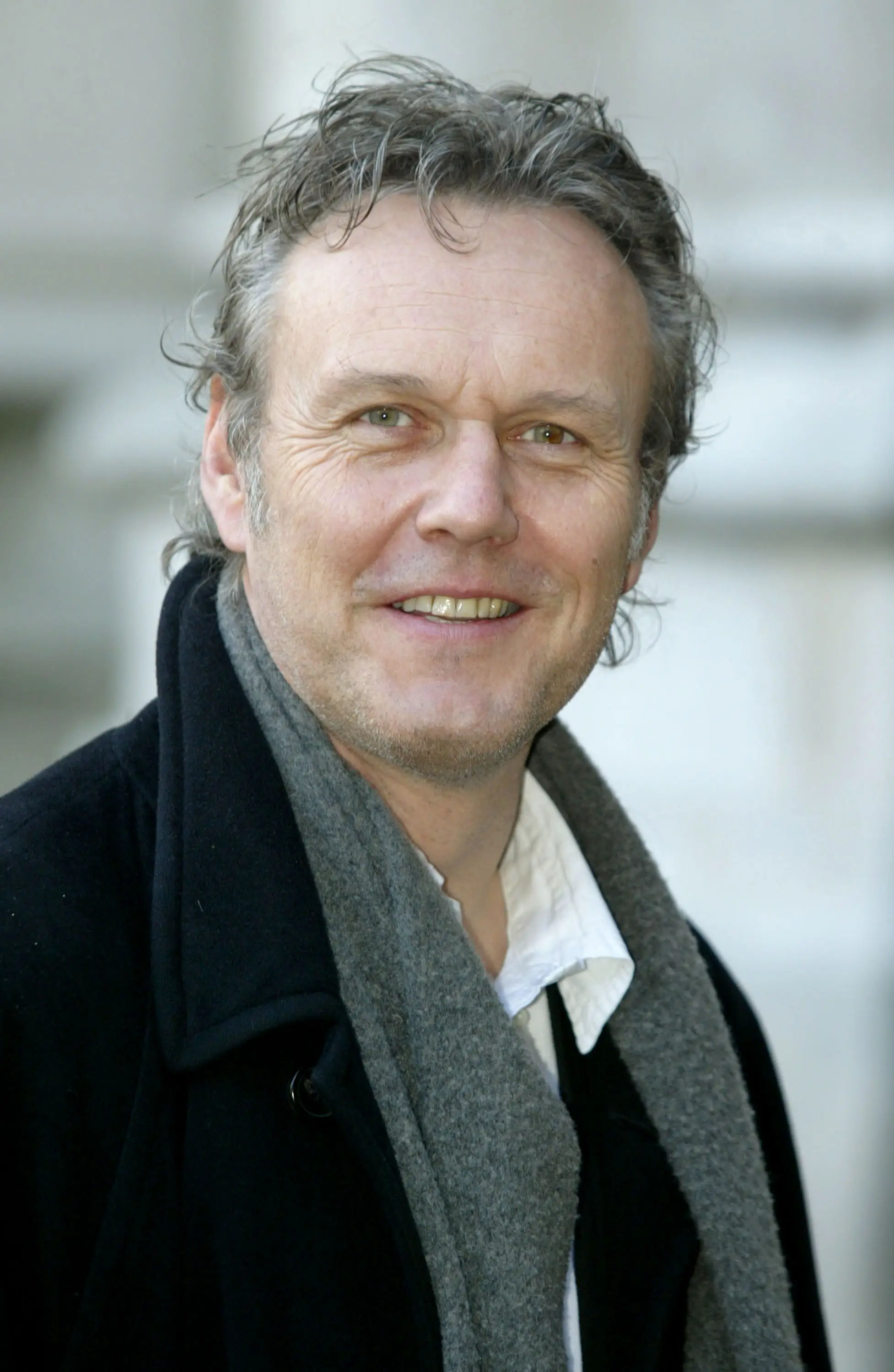 Anthony Head in a black jacket and grey scarf