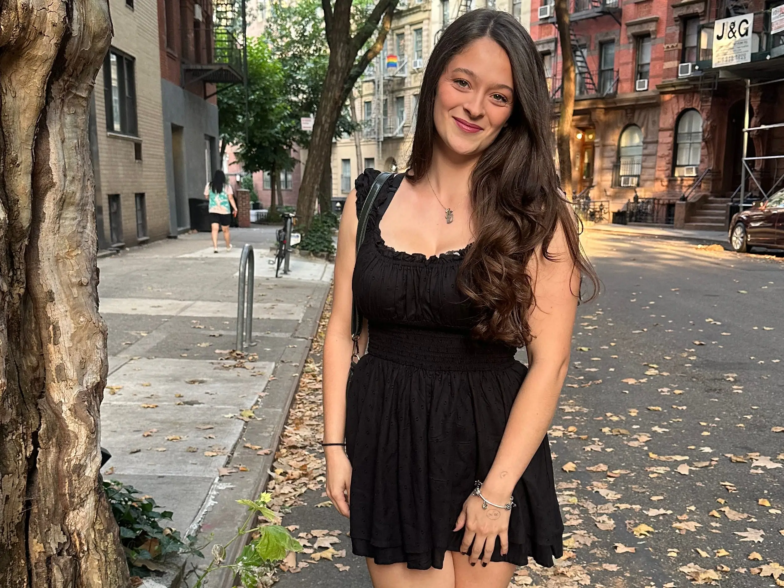Woman in black dress smiling in New York City
