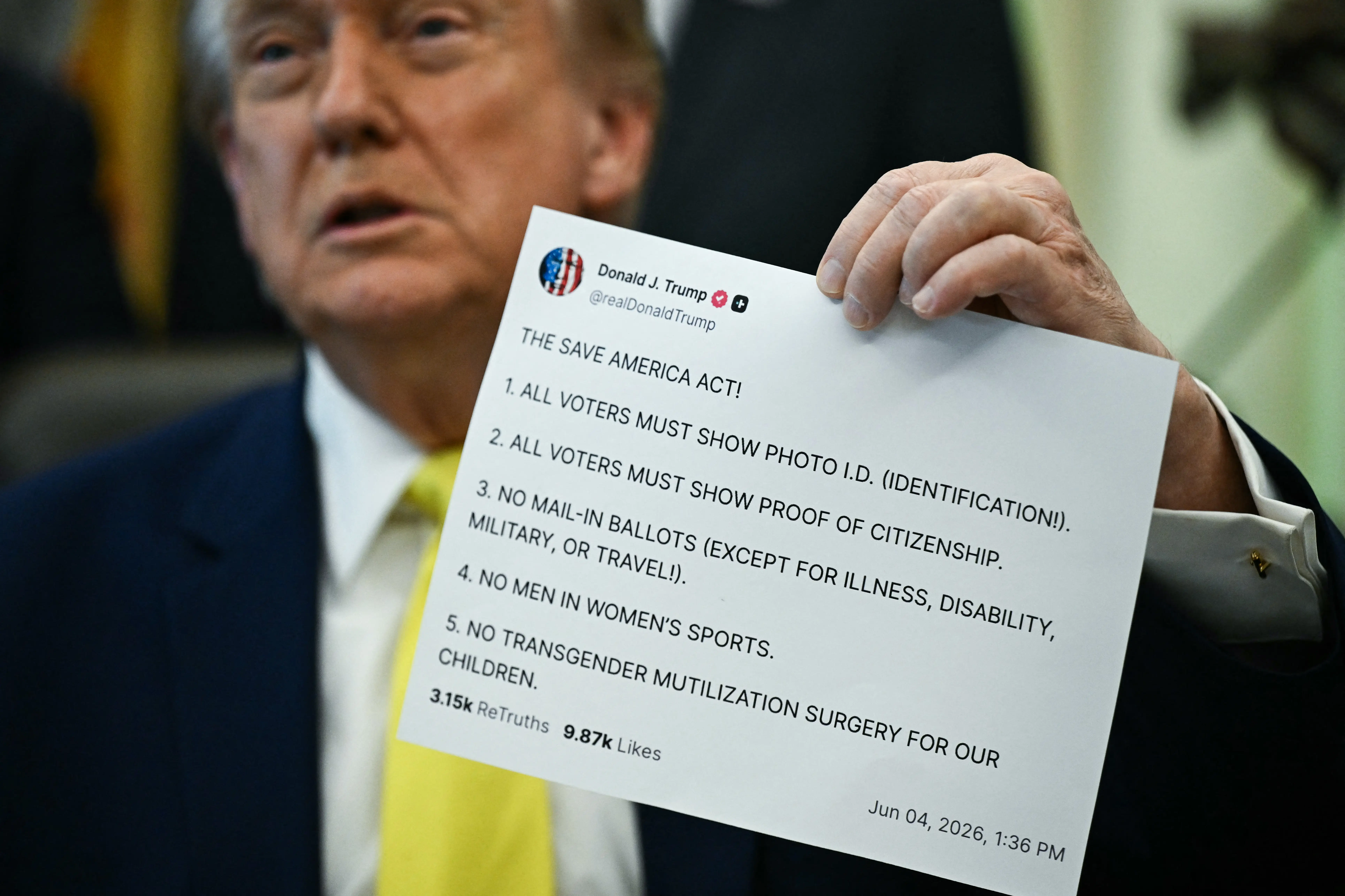 A photo of President Donald Trump holding up a printed out Truth Social post.