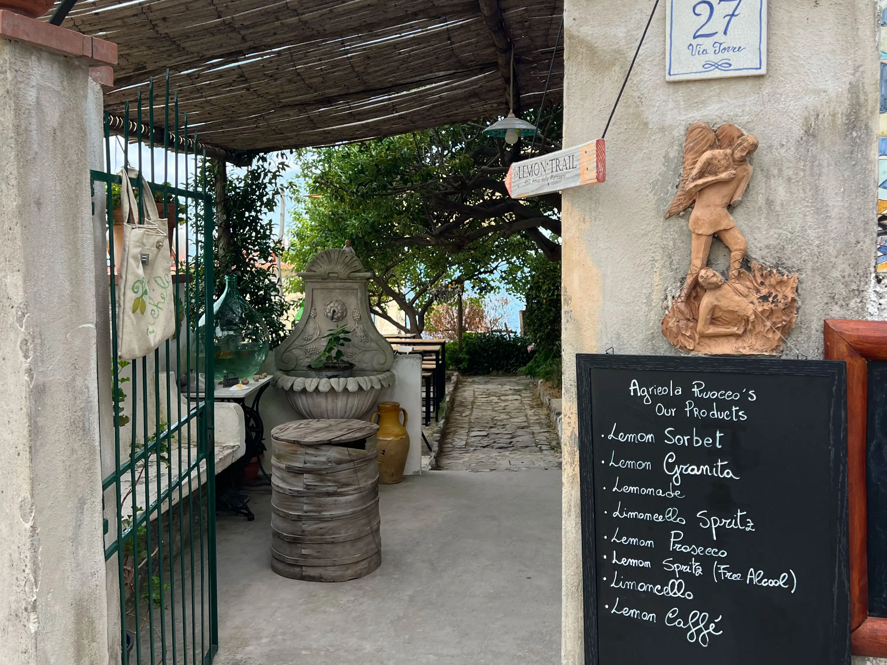 The entrance to a café with a chalkboard sign listing the lemon products for sale.