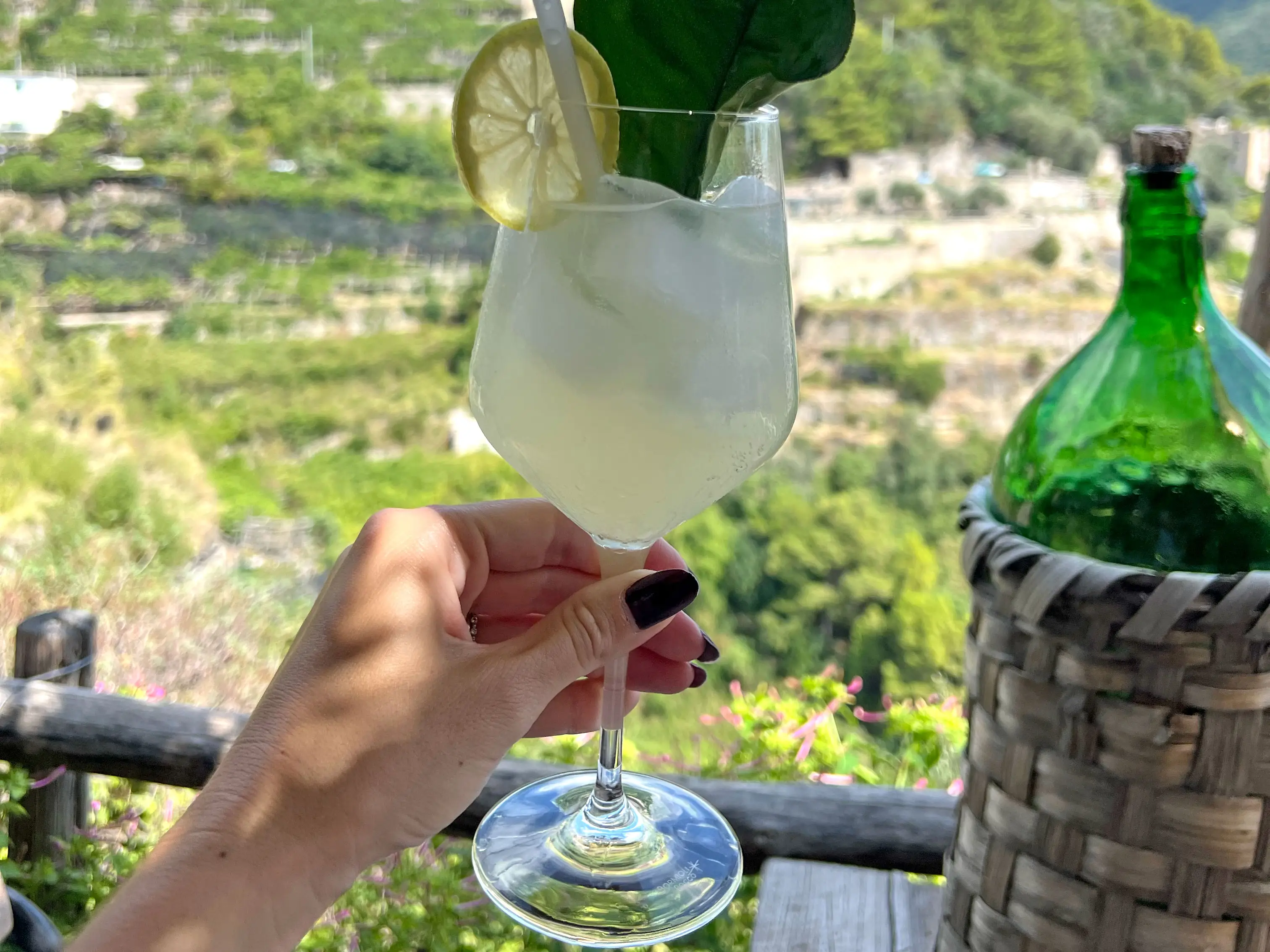 Alexa holds a lemon drink in the air.