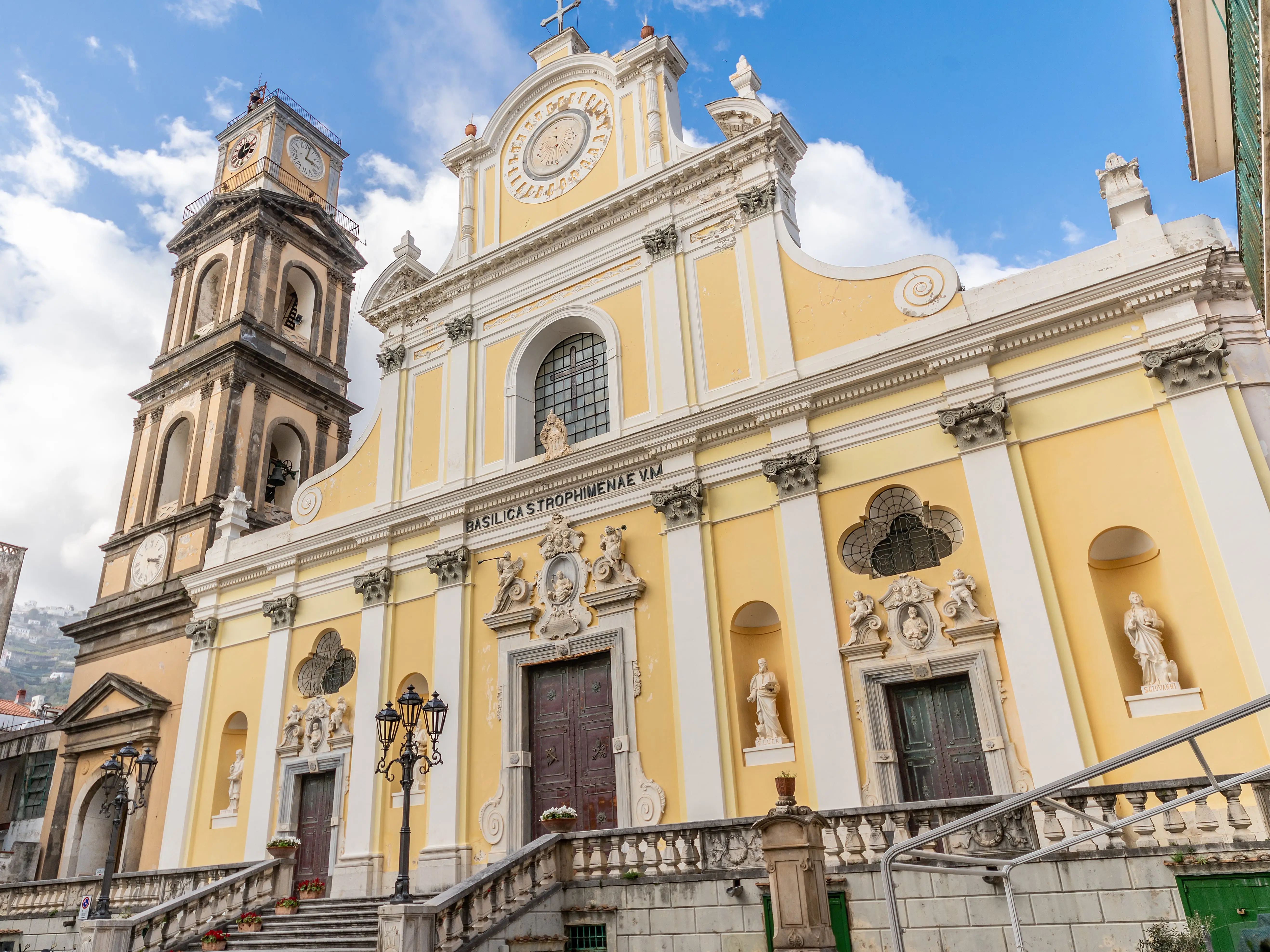 The exterior of the Basilica of Santa Trofimena, a yellow church in Minori.