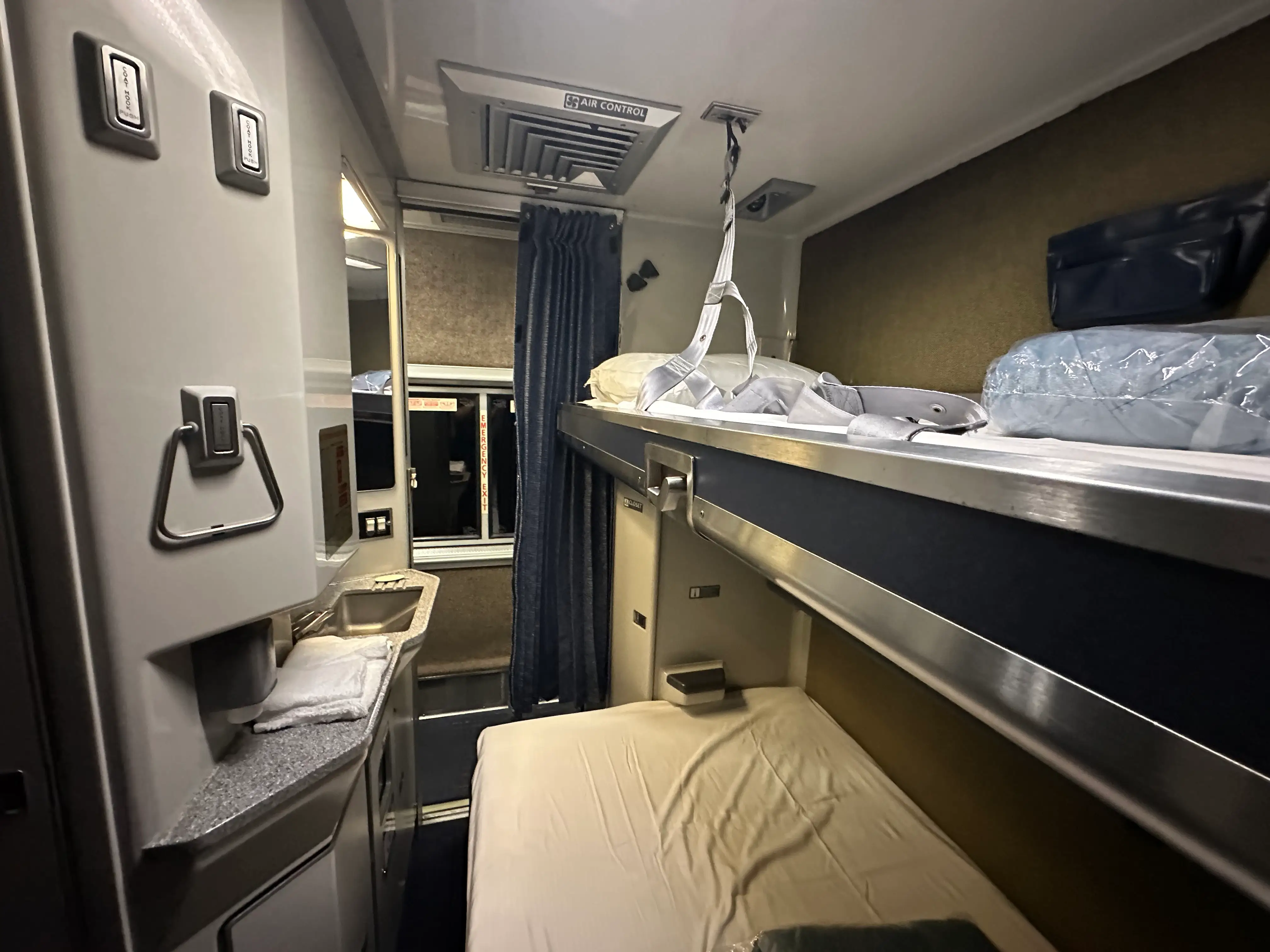 Bed lowered from ceiling with made bed below in private room on  Amtrak Auto Train