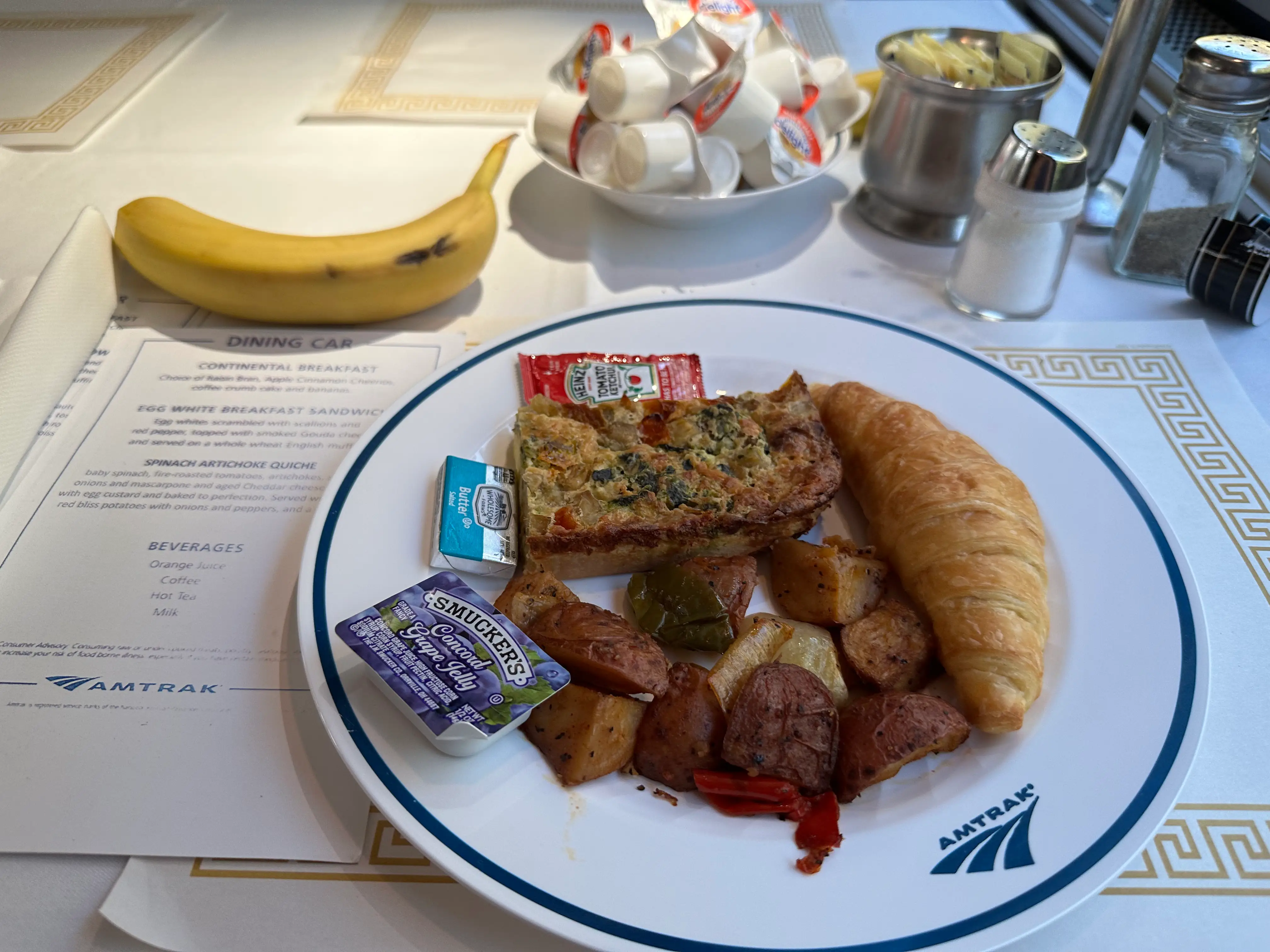 Croissant, quiche, poatoes on plate for breakfast on Amtrak plate on  Amtrak Auto Train