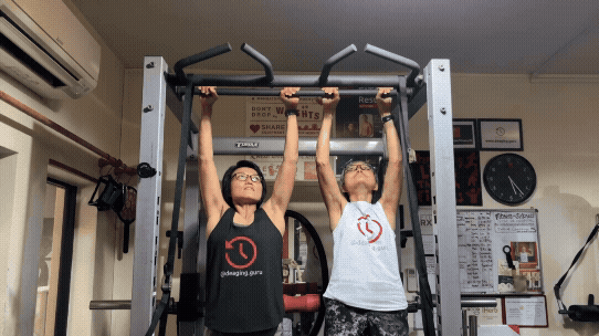 Two women doing a pull up.