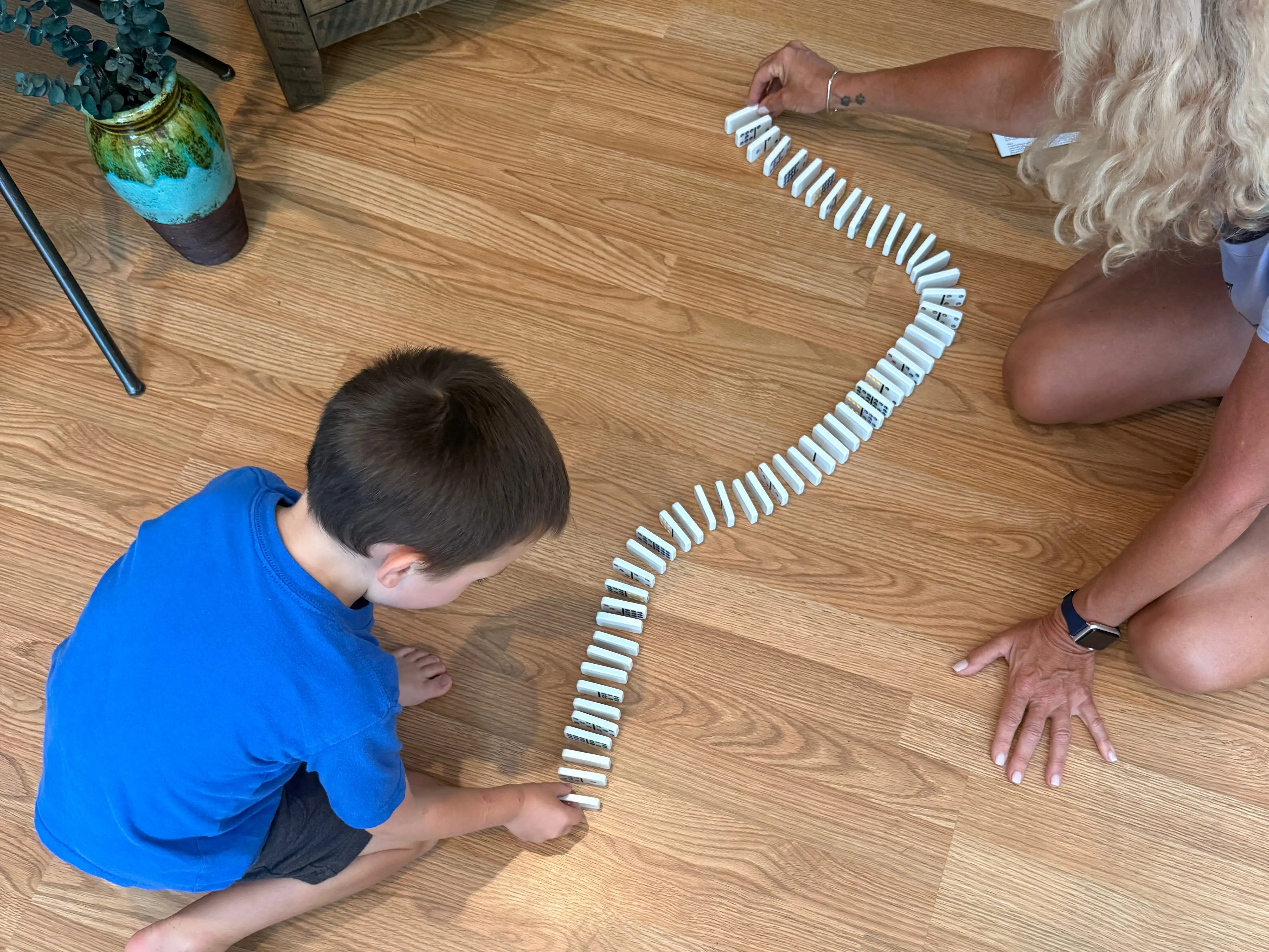 Woman playing dominoes on floor with kid