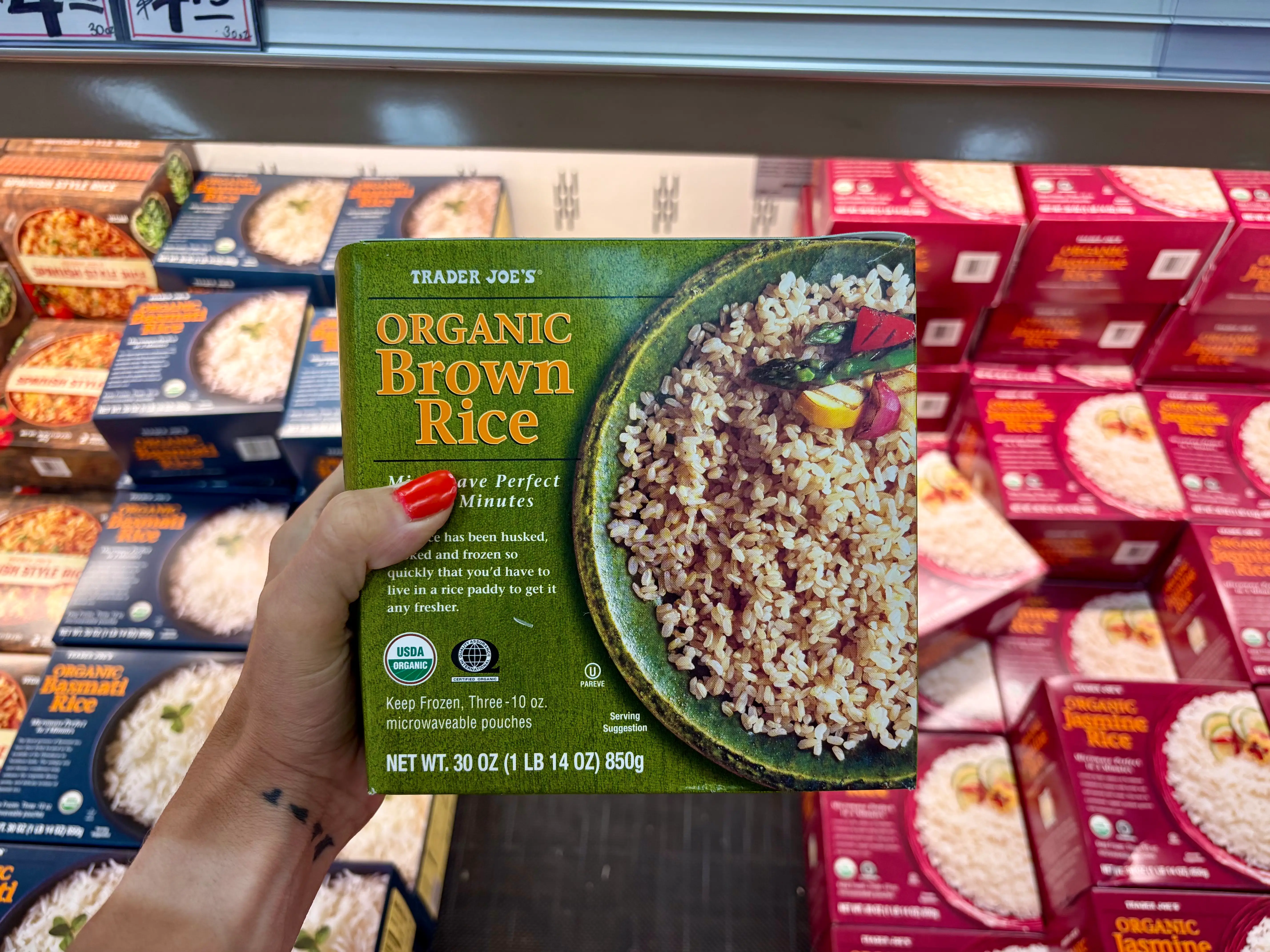 Emily holding a box of Trader Joe's organic brown rice.