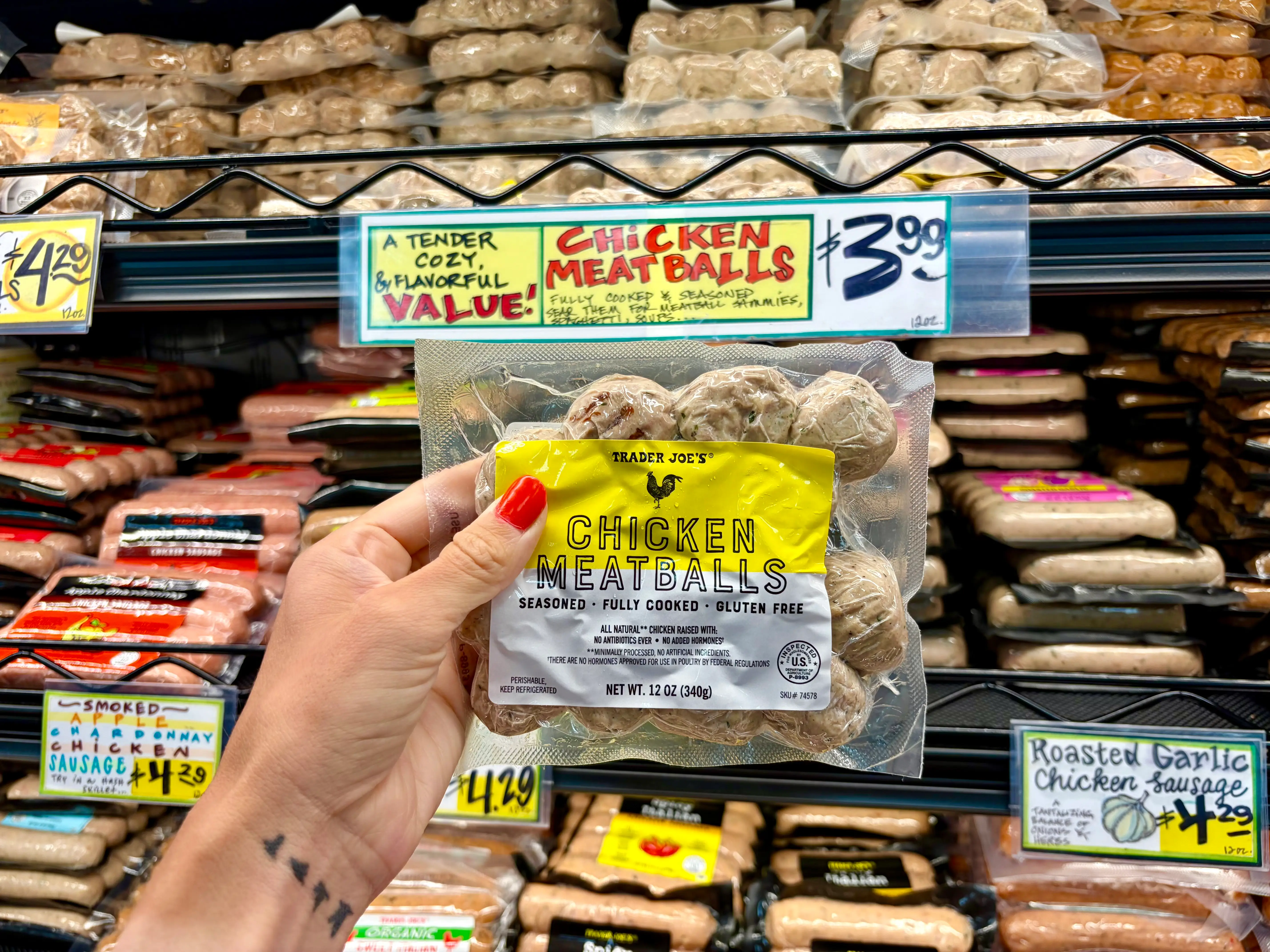 Emily holding a bag of Trader Joe's chicken meatballs.