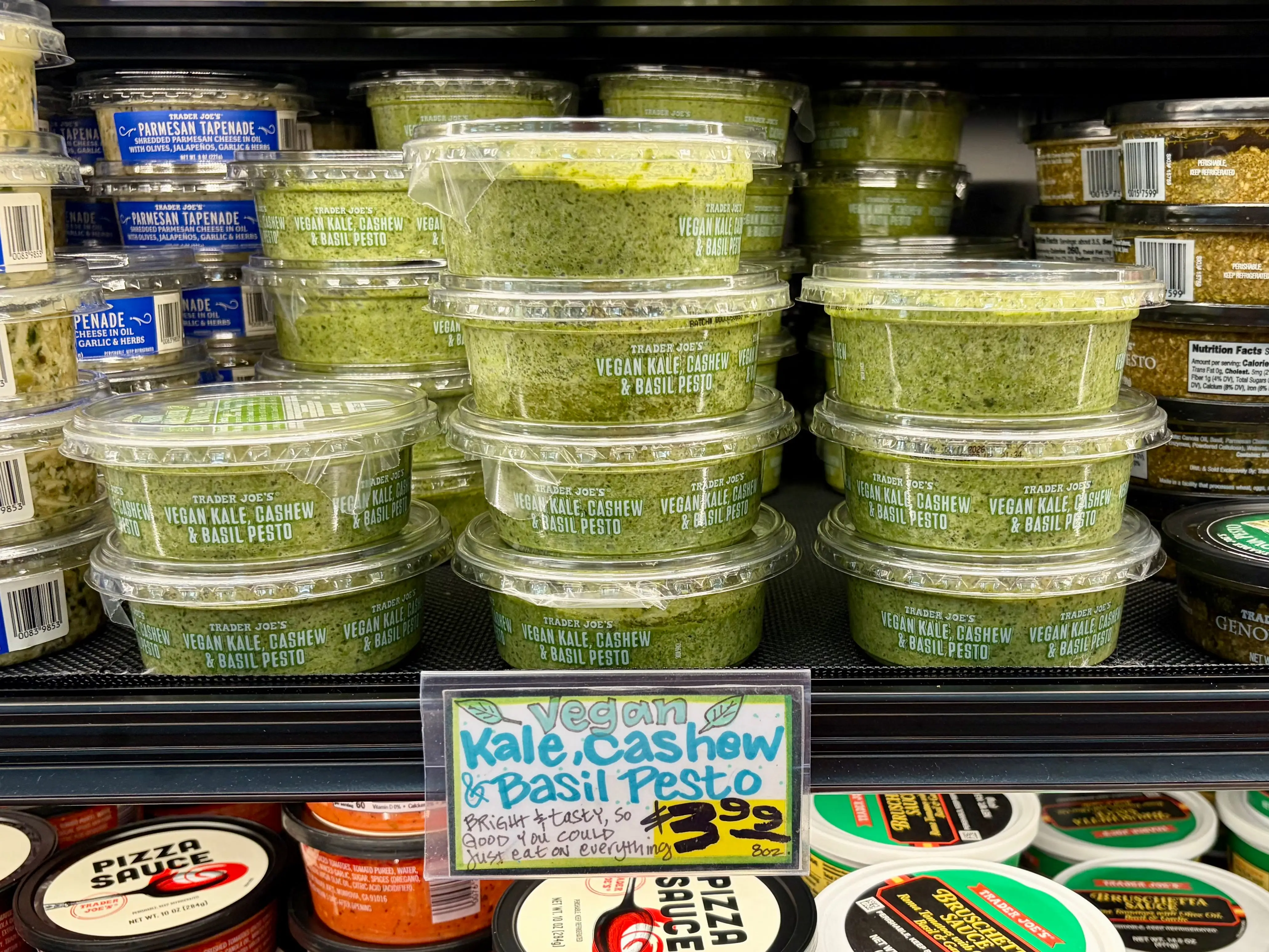 Containers of vegan kale, cashew, and basil pesto.