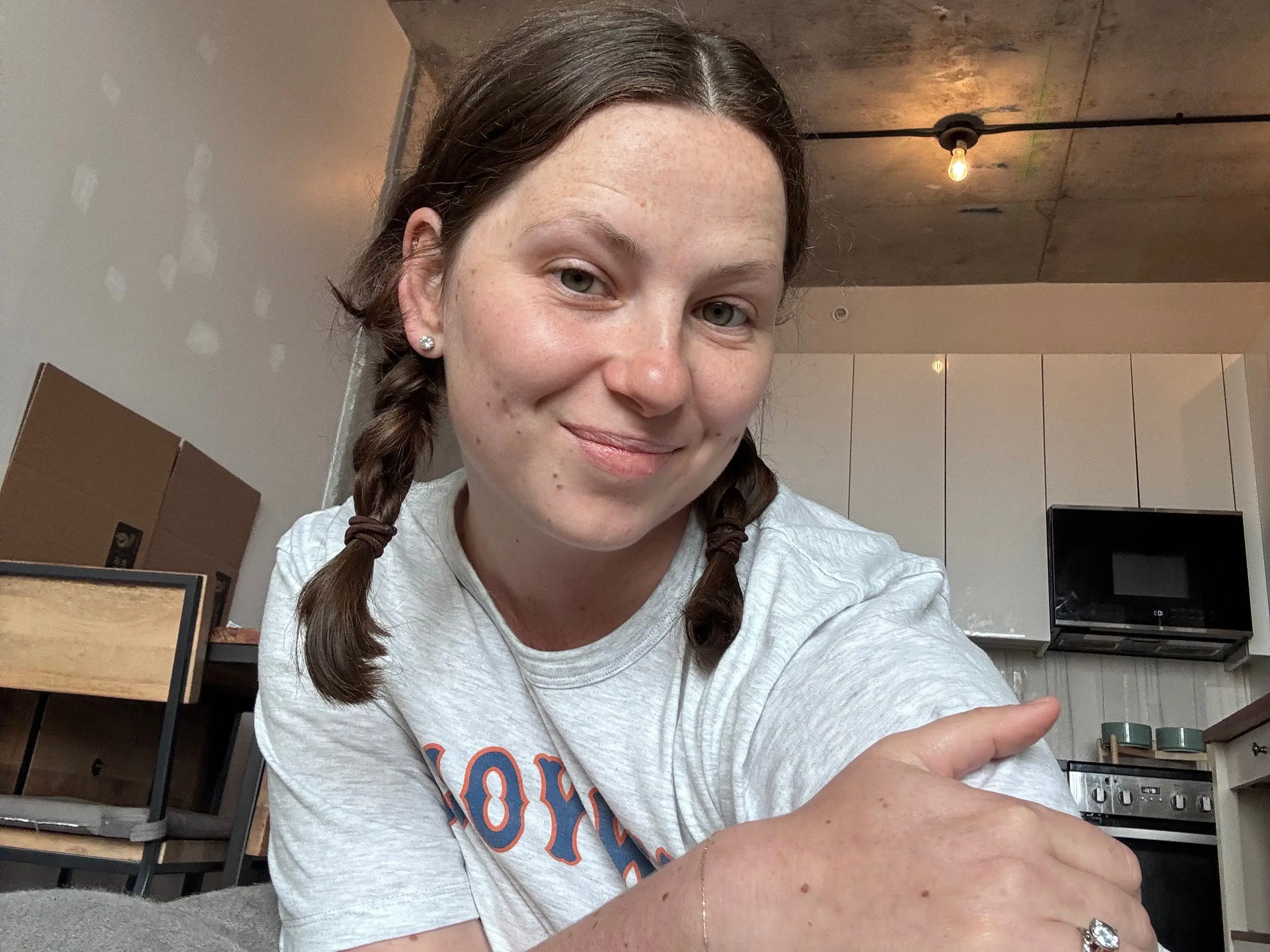 A selfie of a woman in a mostly empty apartment.