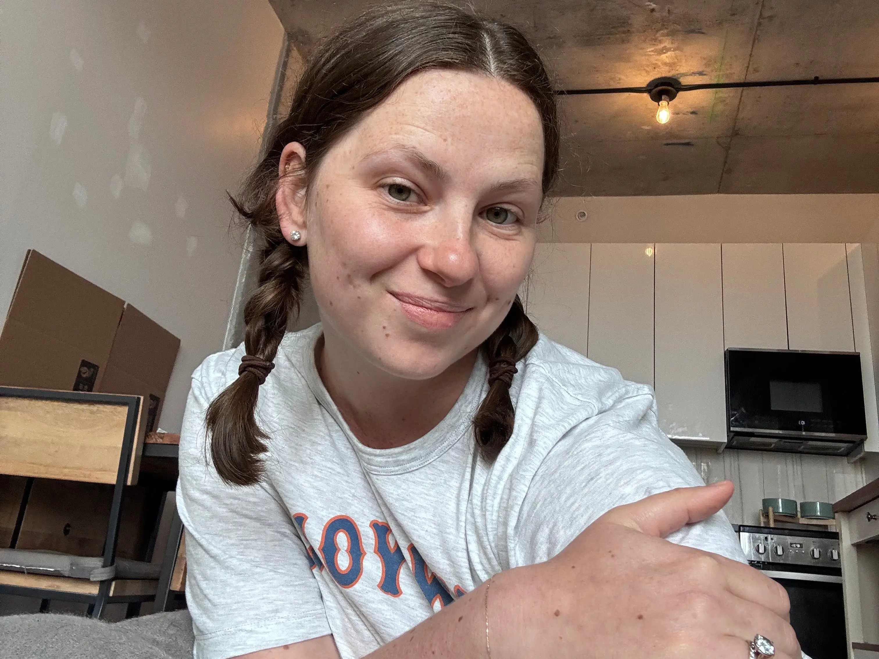A selfie of a woman in a mostly empty apartment.